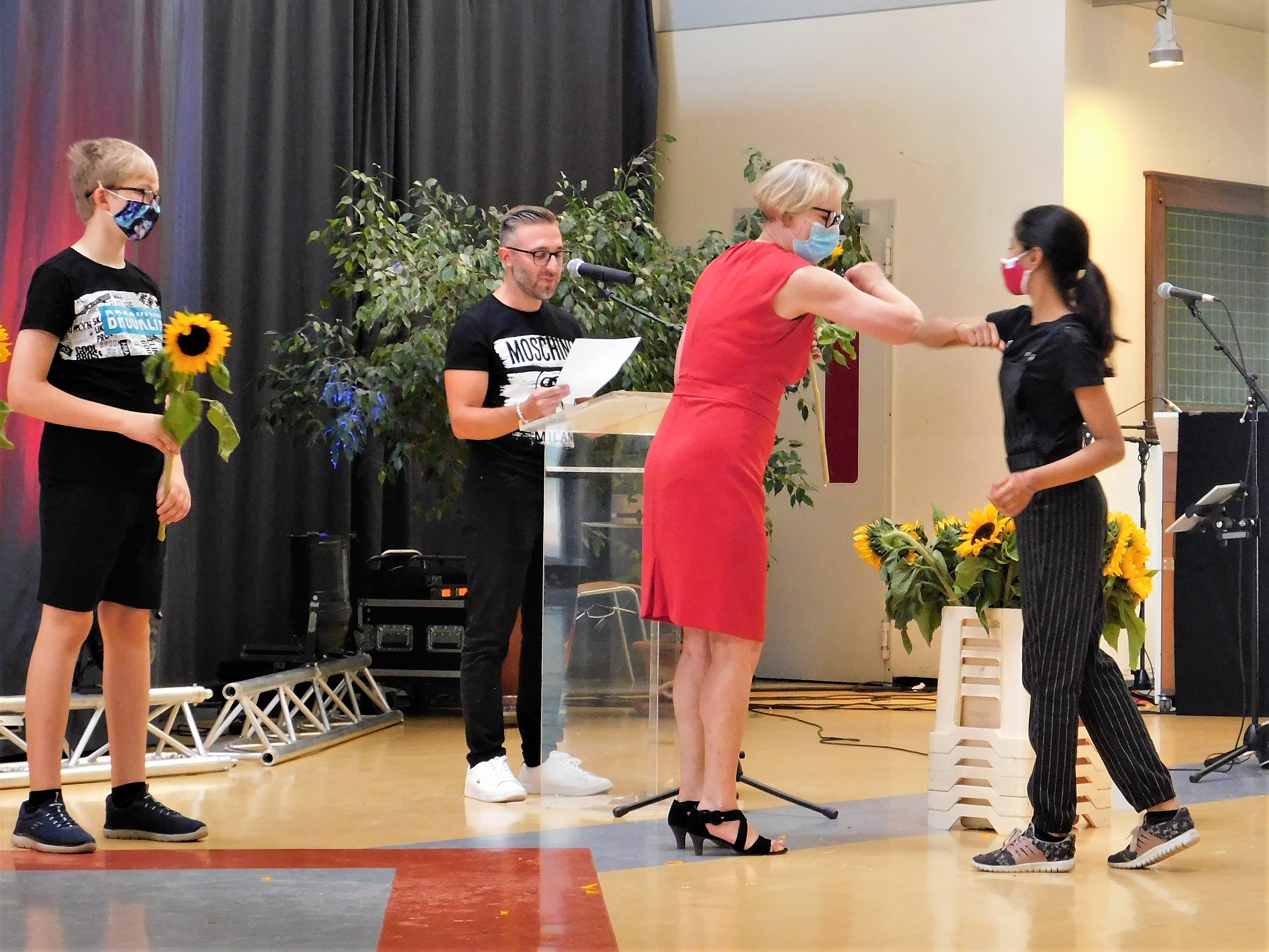 Schulleiterin Elke Wetterau-Bein begrüßt eine Schülerin mit dem Ellenbogencheck. Beide tragen eine Maske.