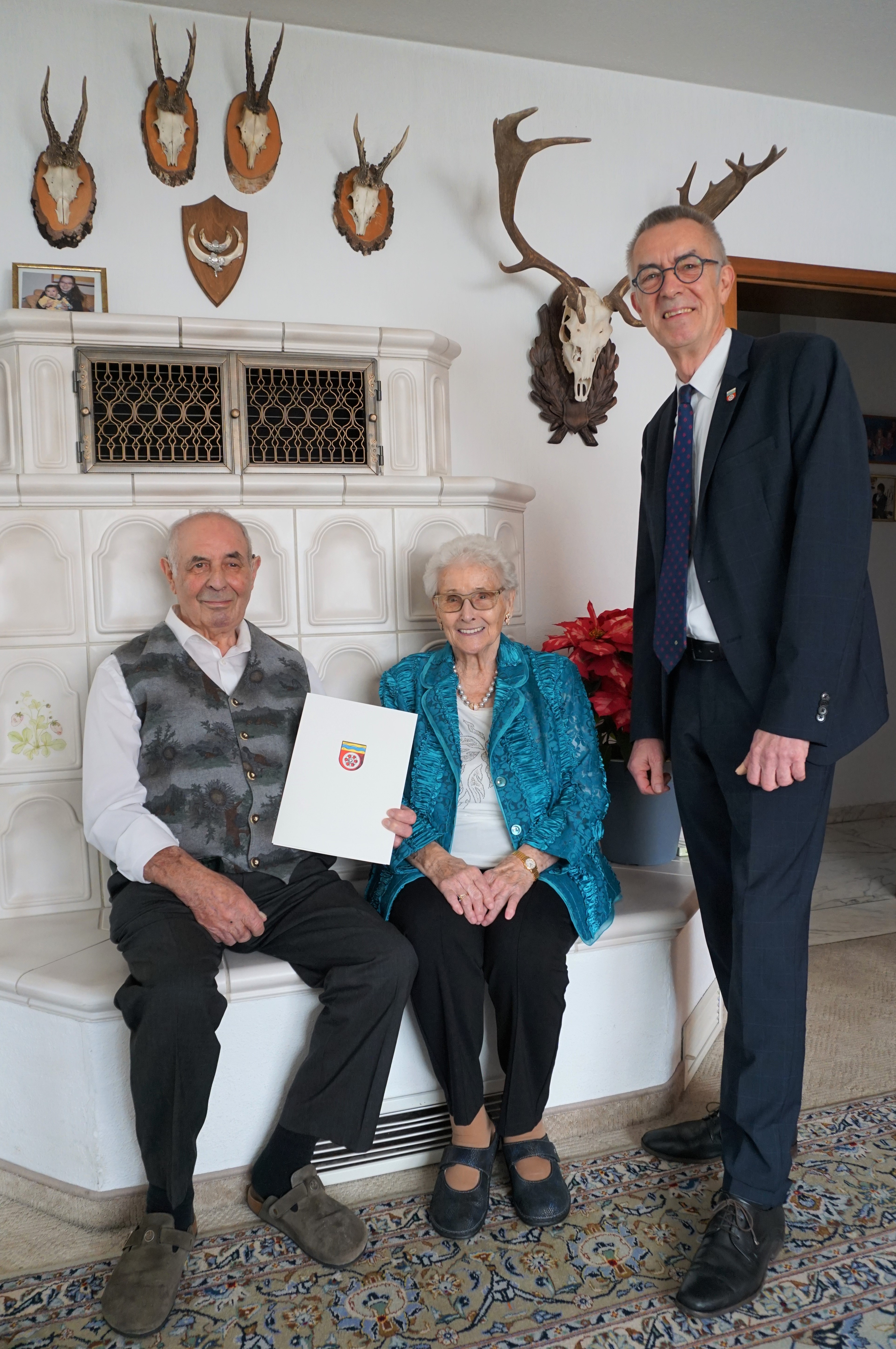 Das Ehepaar SChulte-Oestrich vor dem Kachelofen, daneben steht Franz Jirasek.