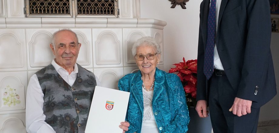 Das Ehepaar SChulte-Oestrich vor dem Kachelofen, daneben steht Franz Jirasek.