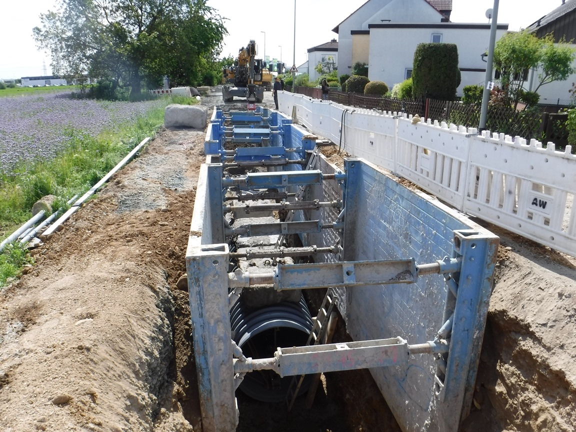 Eine große Baustelle mit Beton und Kanalrohren im Holzweg.
