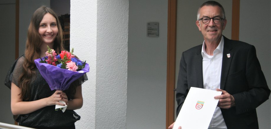 Anna Weis mit Franz Jirasek, Blumenstrauß und Urkunde.