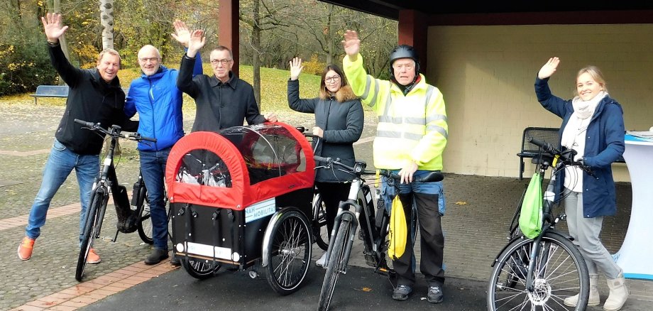 Die Ausleiher der letzten E-Bikes beim Rückgabetermin winken fröhlich in die Kamera.