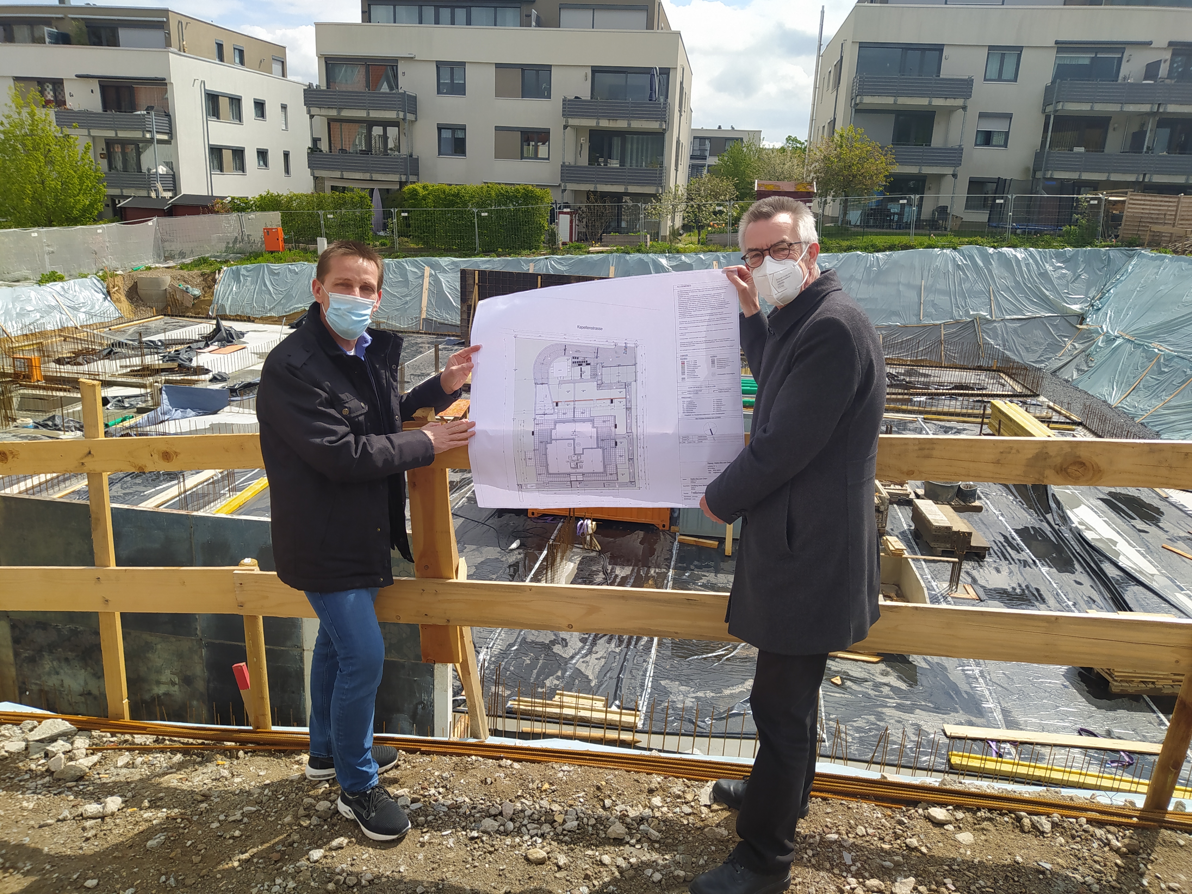 Franz Jirasek und Jürger Röll an der Baustelle. Sie halten einen Bauplan in der Hand.