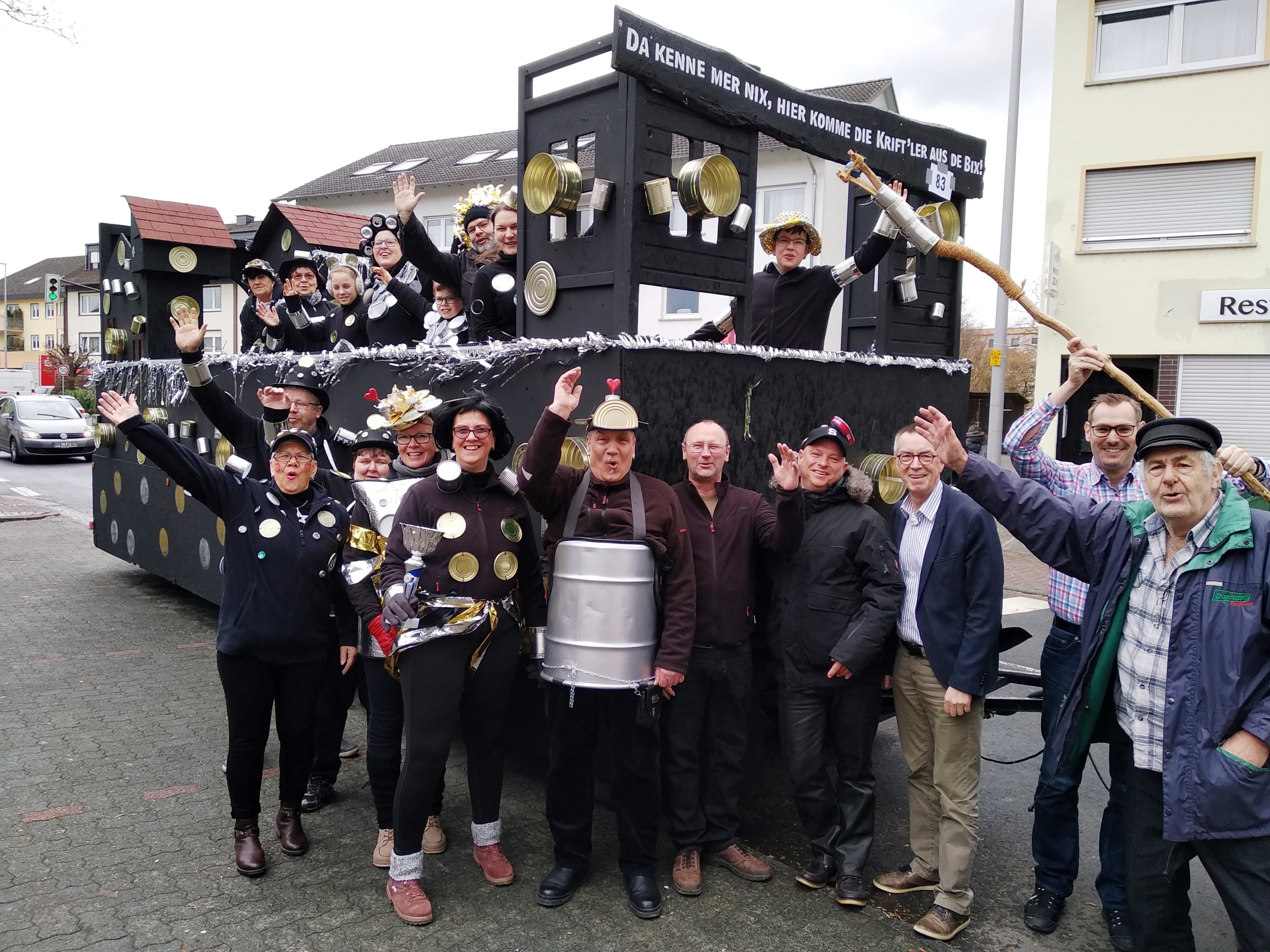 Die Narren vom Heimat- und Geschichtsverein vor dem Umzugswagen. Alle geschmückt mit leeren Dosen.