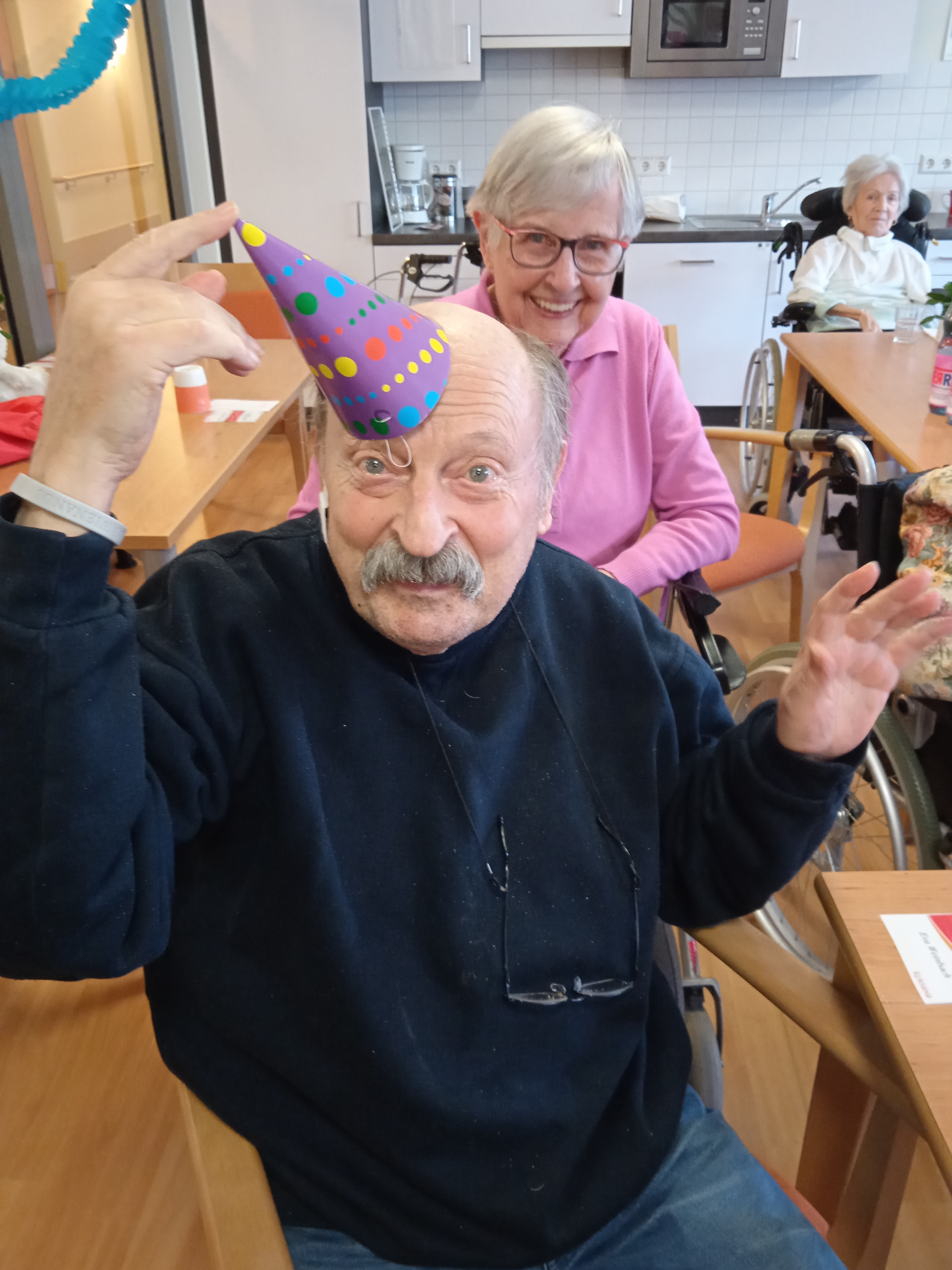 Ein älterer Herr hält sich eine Kappe auf die Stirn.