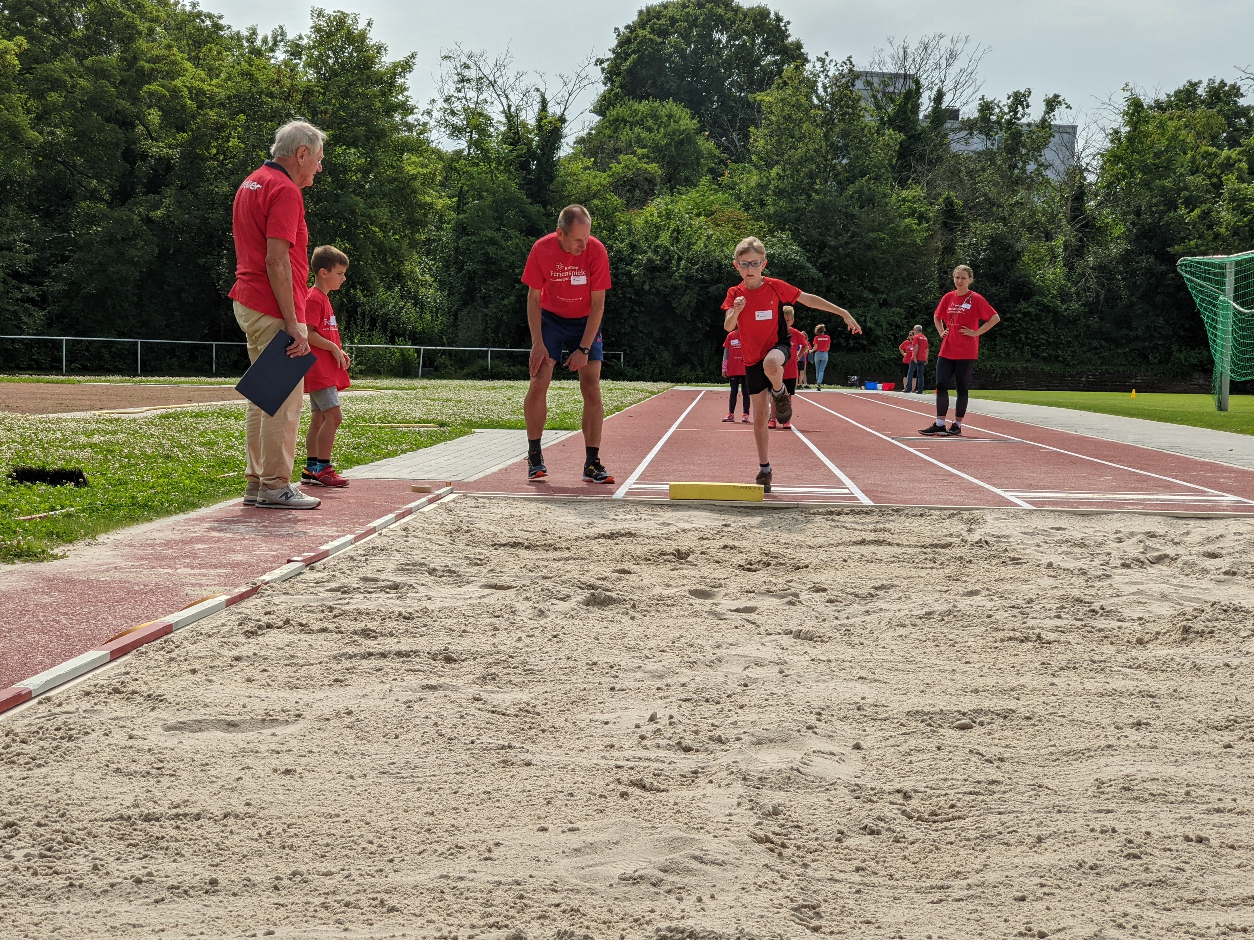 Ein Kind springt in die Sprunggrube.