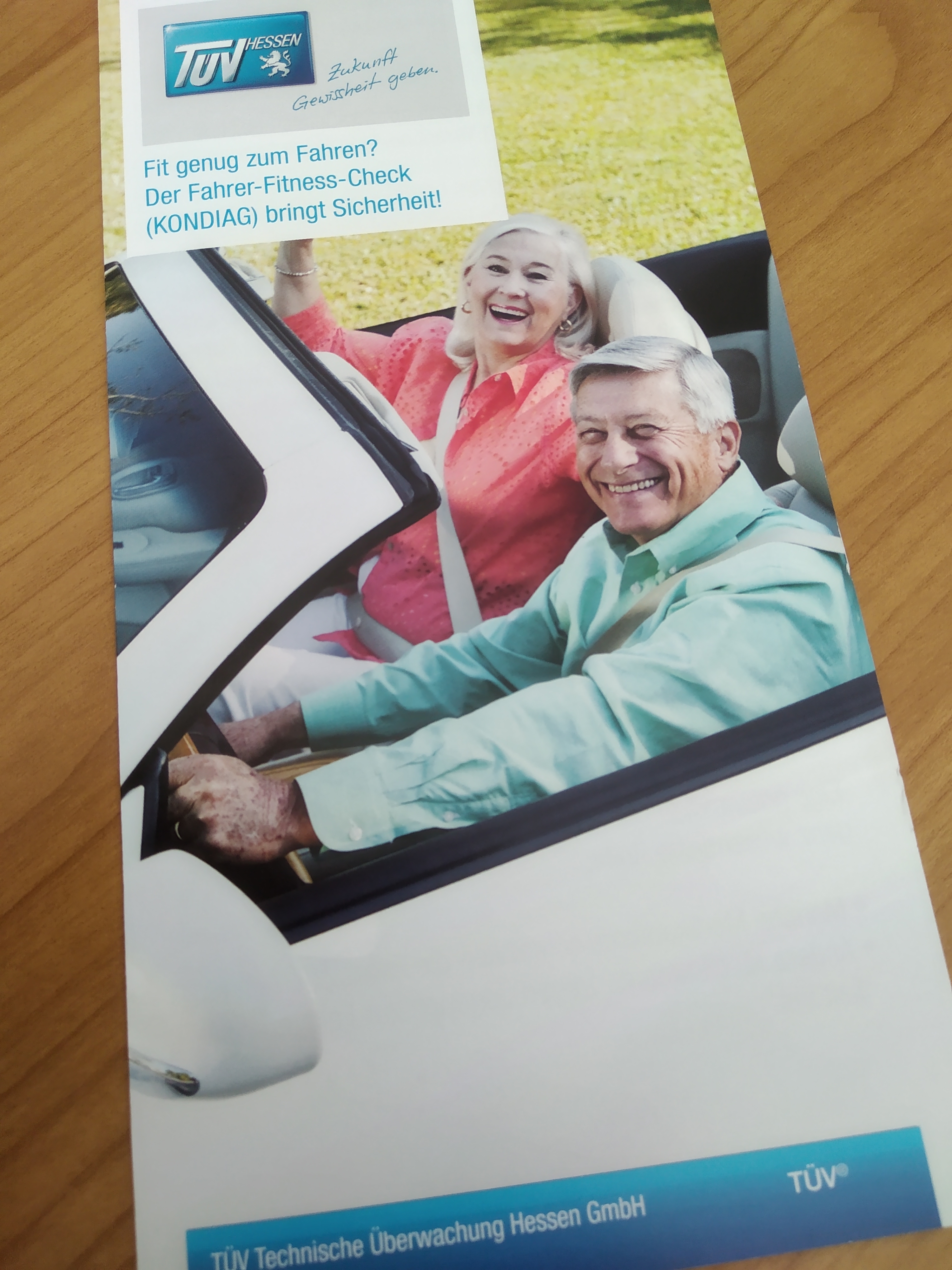 Zwei Senioren sitzen gut gelaunt im Cabrio.