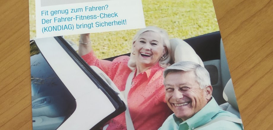 Zwei Senioren sitzen gut gelaunt im Cabrio.
