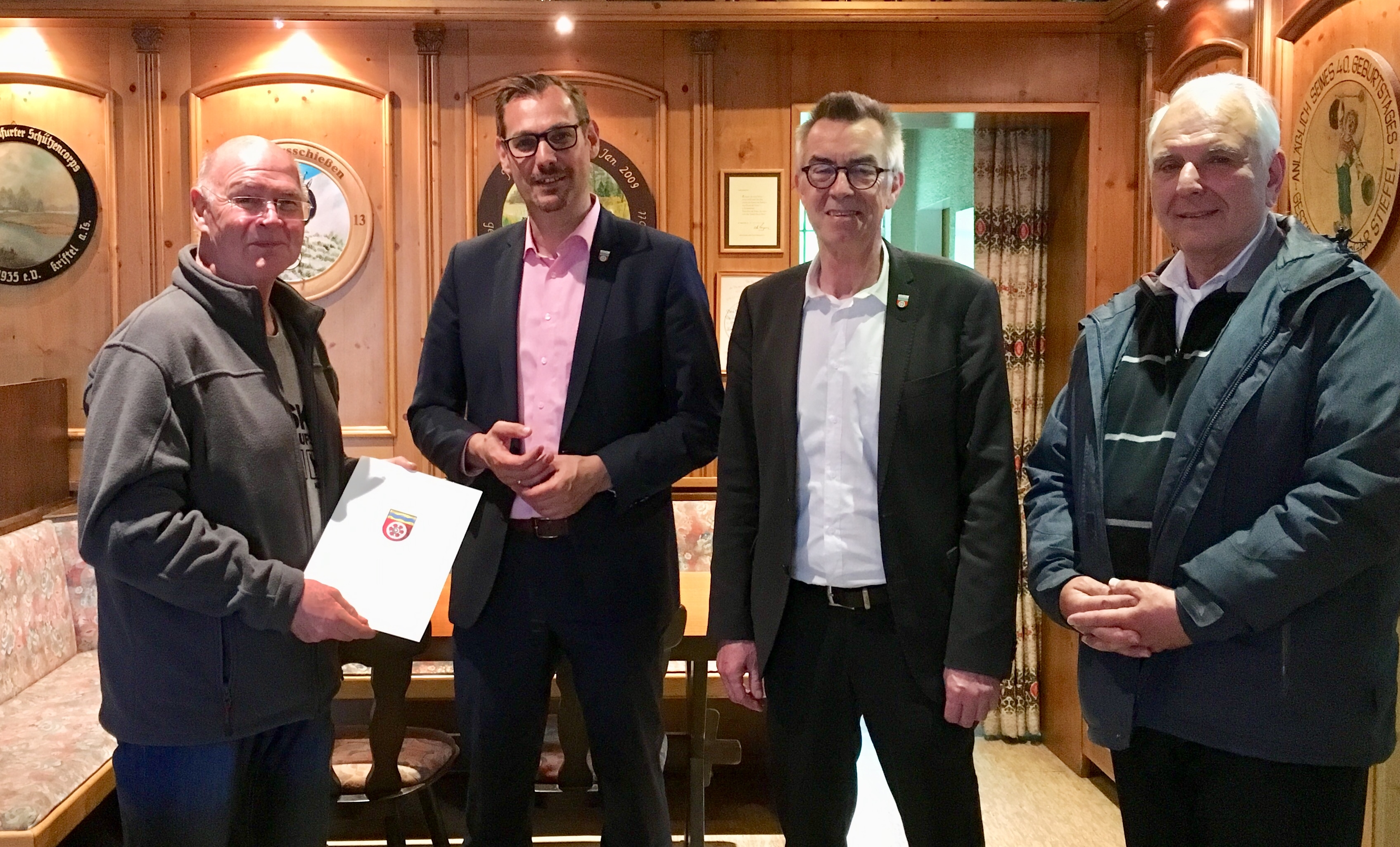Der Bürgermeister, der Erste Beigeordnete und der Parlamentschef übergeben den Check an den Vorsitzenden des Schützenvereins.