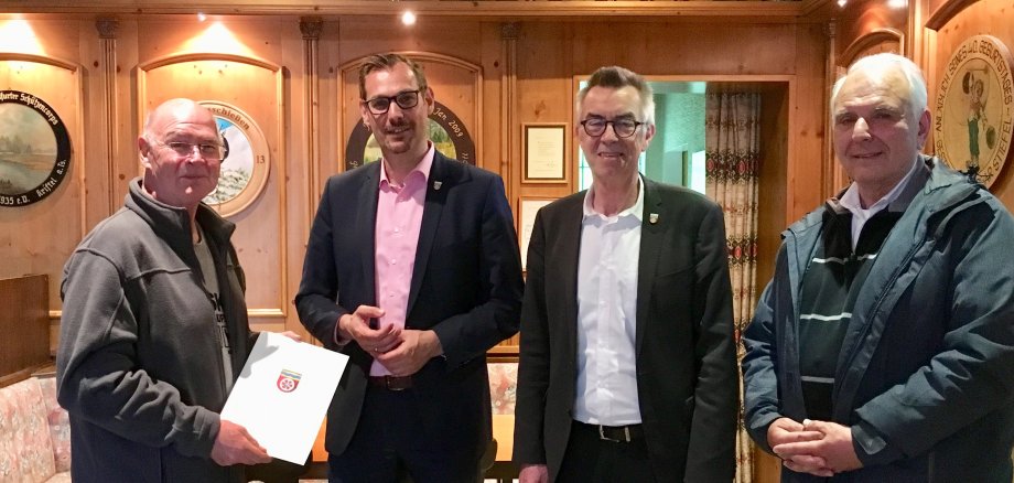 Der Bürgermeister, der Erste Beigeordnete und der Parlamentschef übergeben den Check an den Vorsitzenden des Schützenvereins.