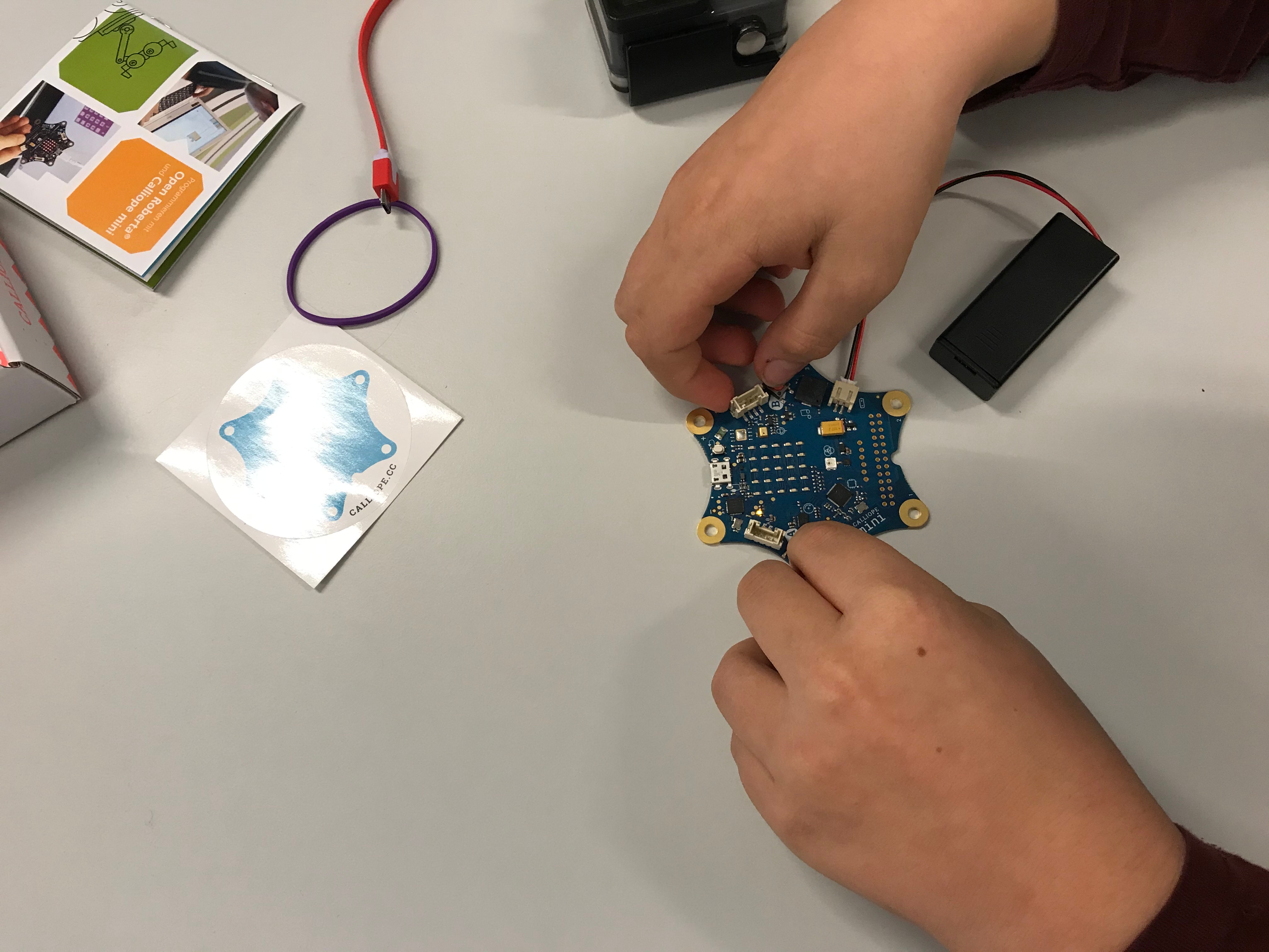 Zwei Hände und ein Computerbastelset.