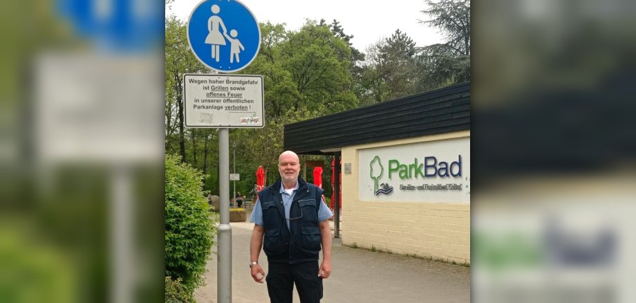 Ordnungspolizist neben Schild.