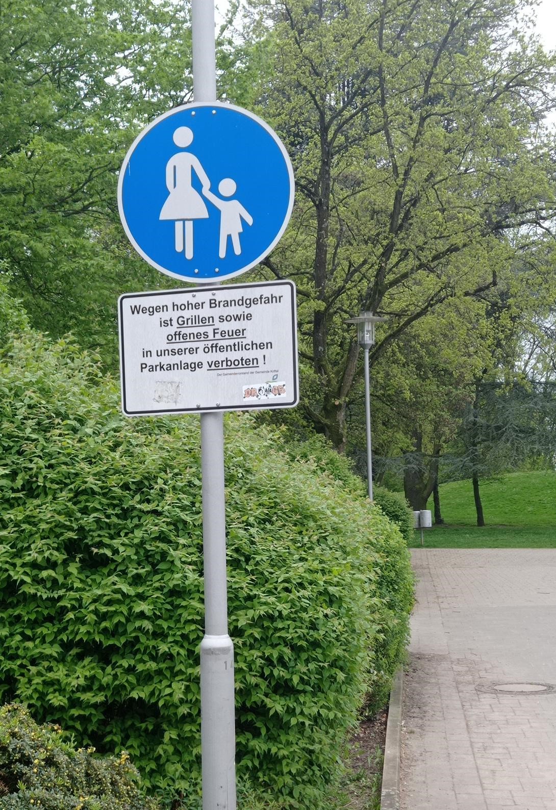 Blaues Gehweg-Schild mit weißen Fußgängern.