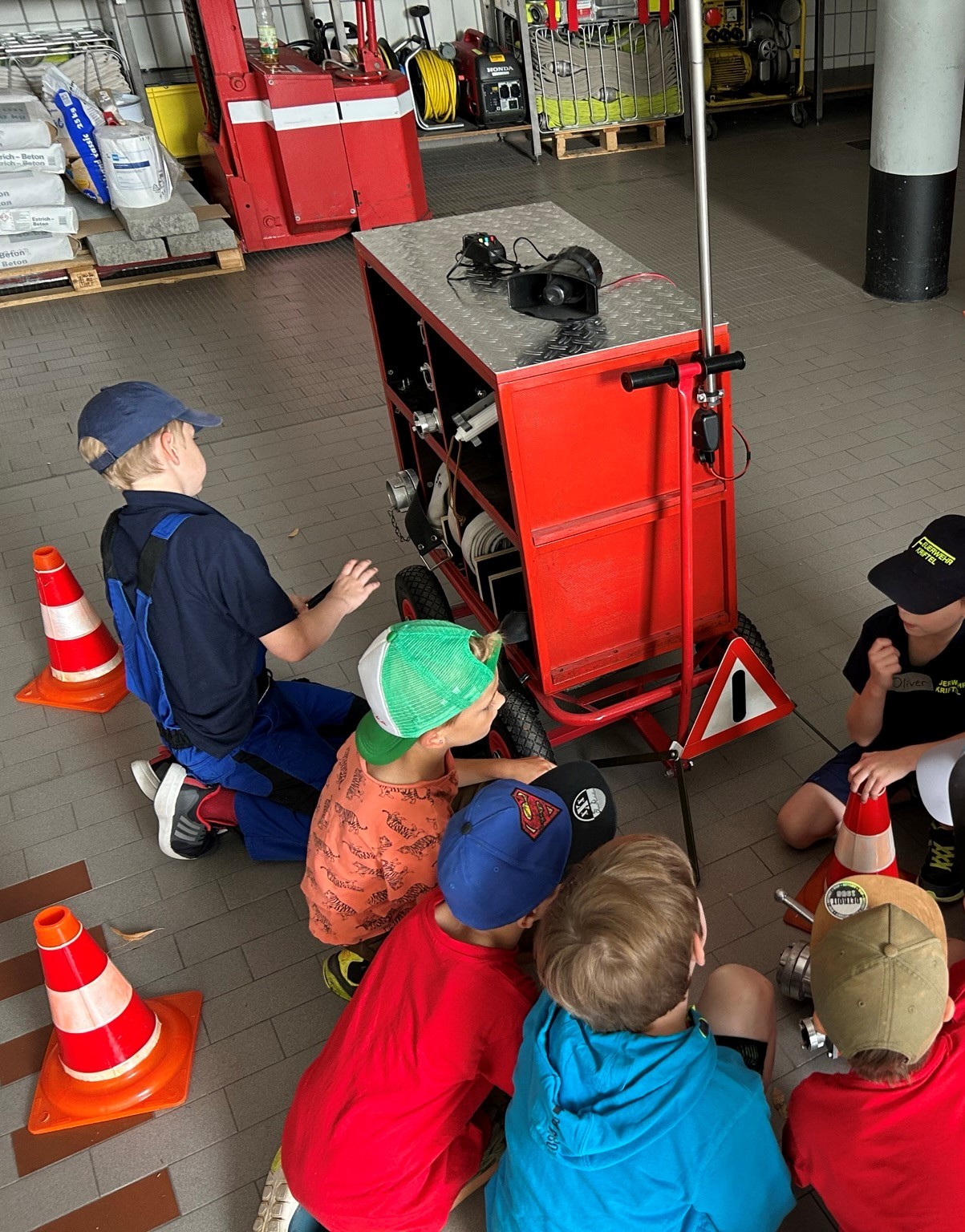 Kinder hocken vor einem Materialschrank.