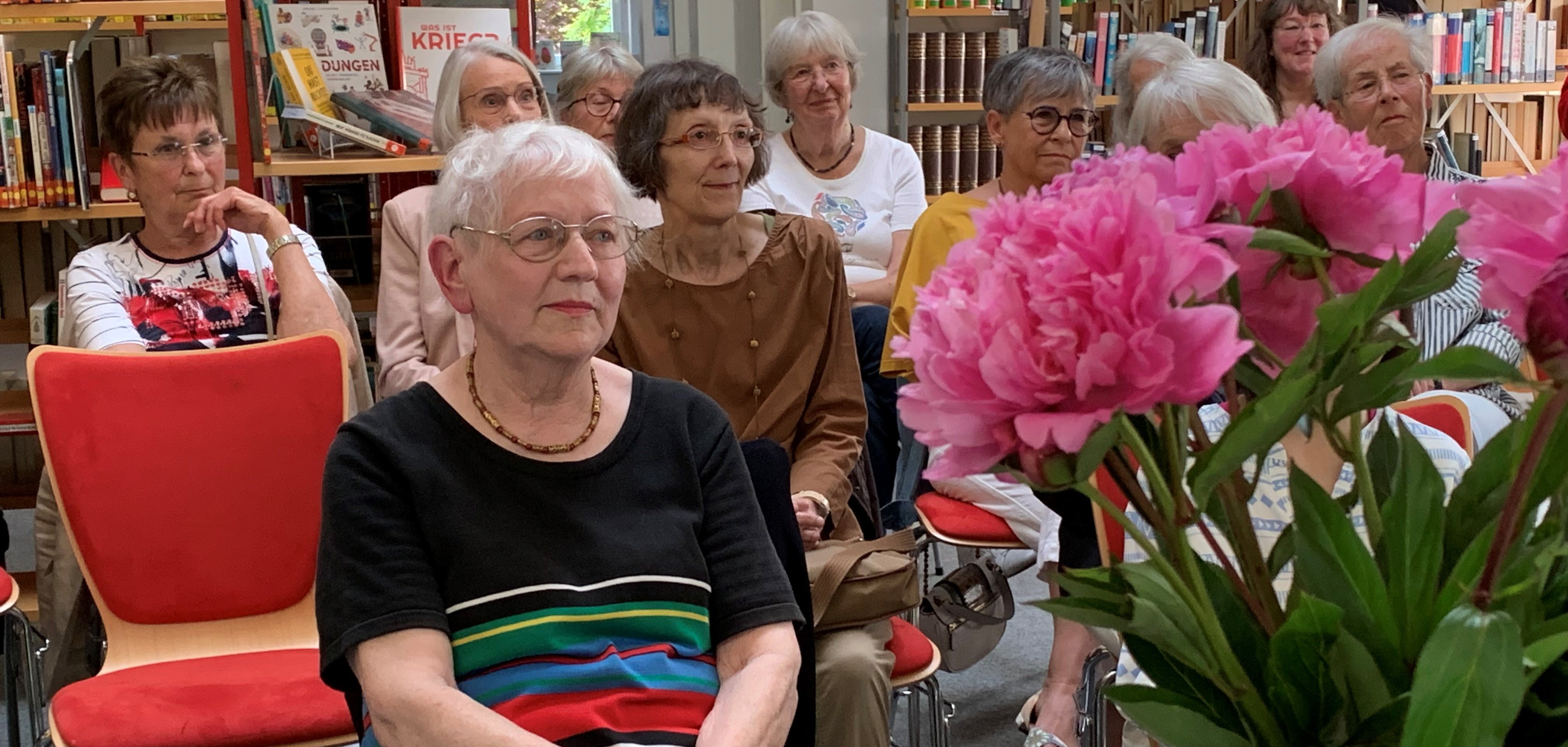 Frau Hadiprono neben einem Blumenstrauß.