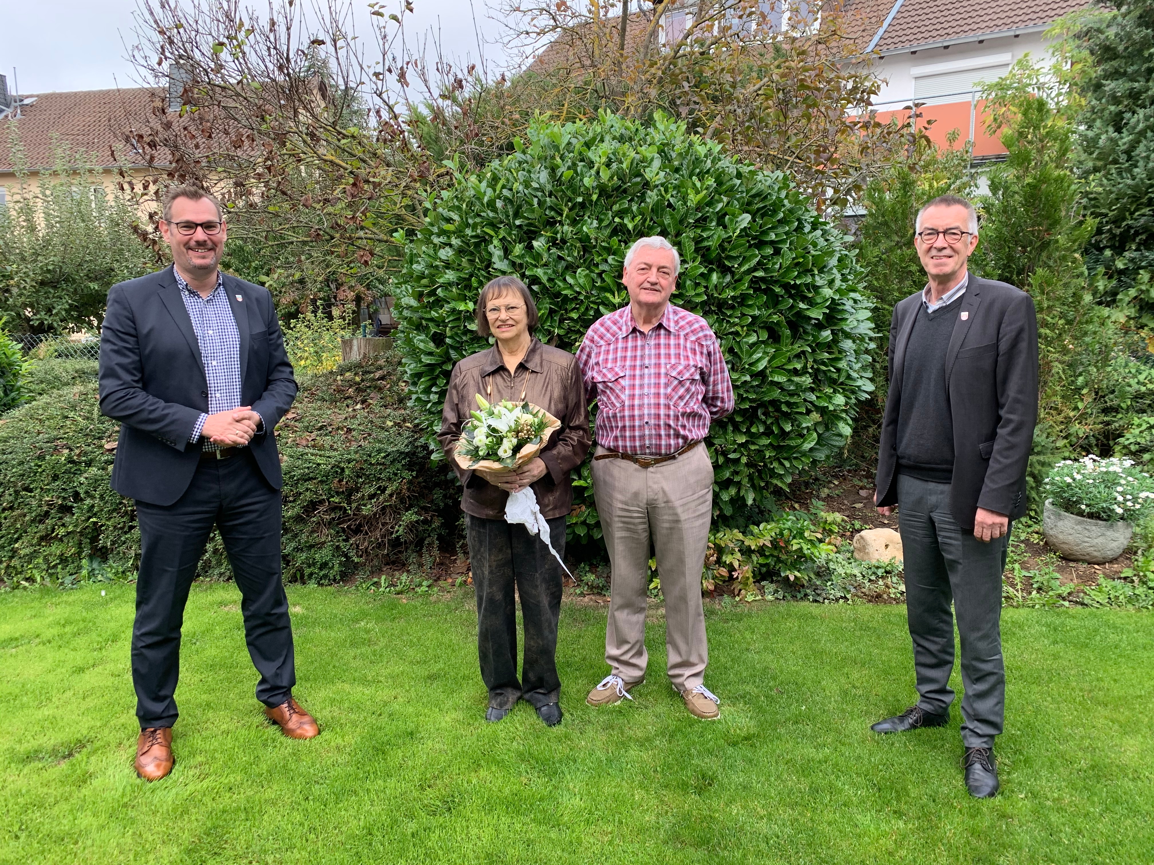 Bürgermeister Seitz und Franz Jirasek mit dem Paar im Garten der Familie. Alle stehen mit Abstand.