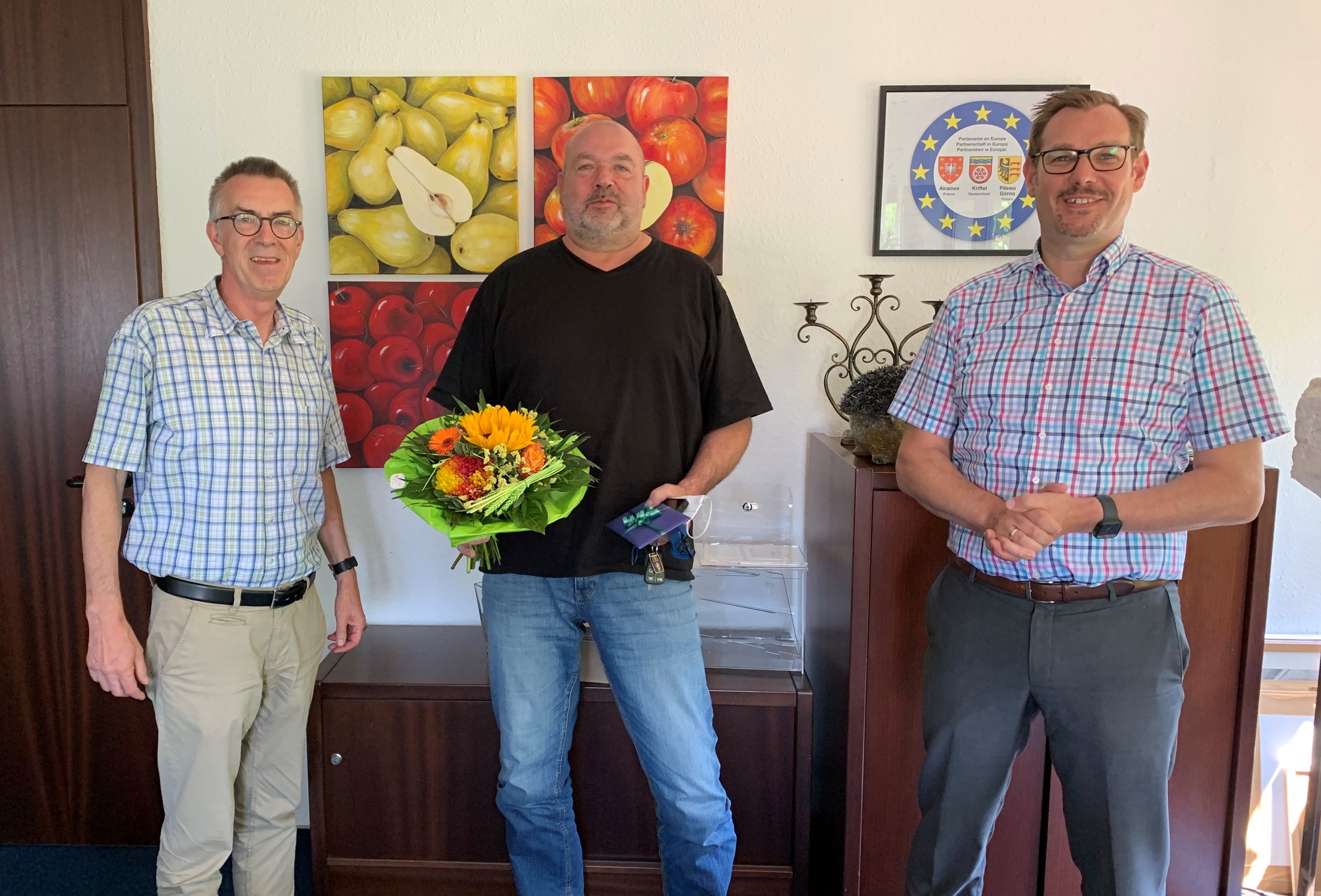 Klaus Bothur mit Blumenstaruß neben Seitz und jirasek im Büro des Bürgermeisters.