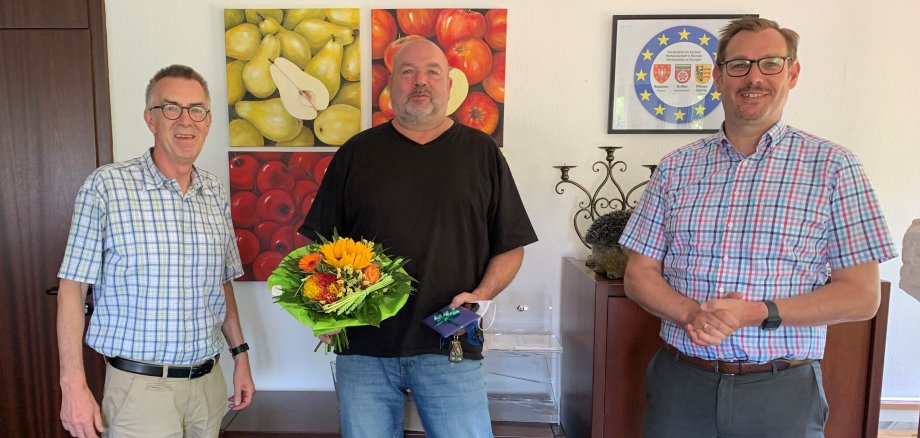 Klaus Bothur mit Blumenstaruß neben Seitz und jirasek im Büro des Bürgermeisters.