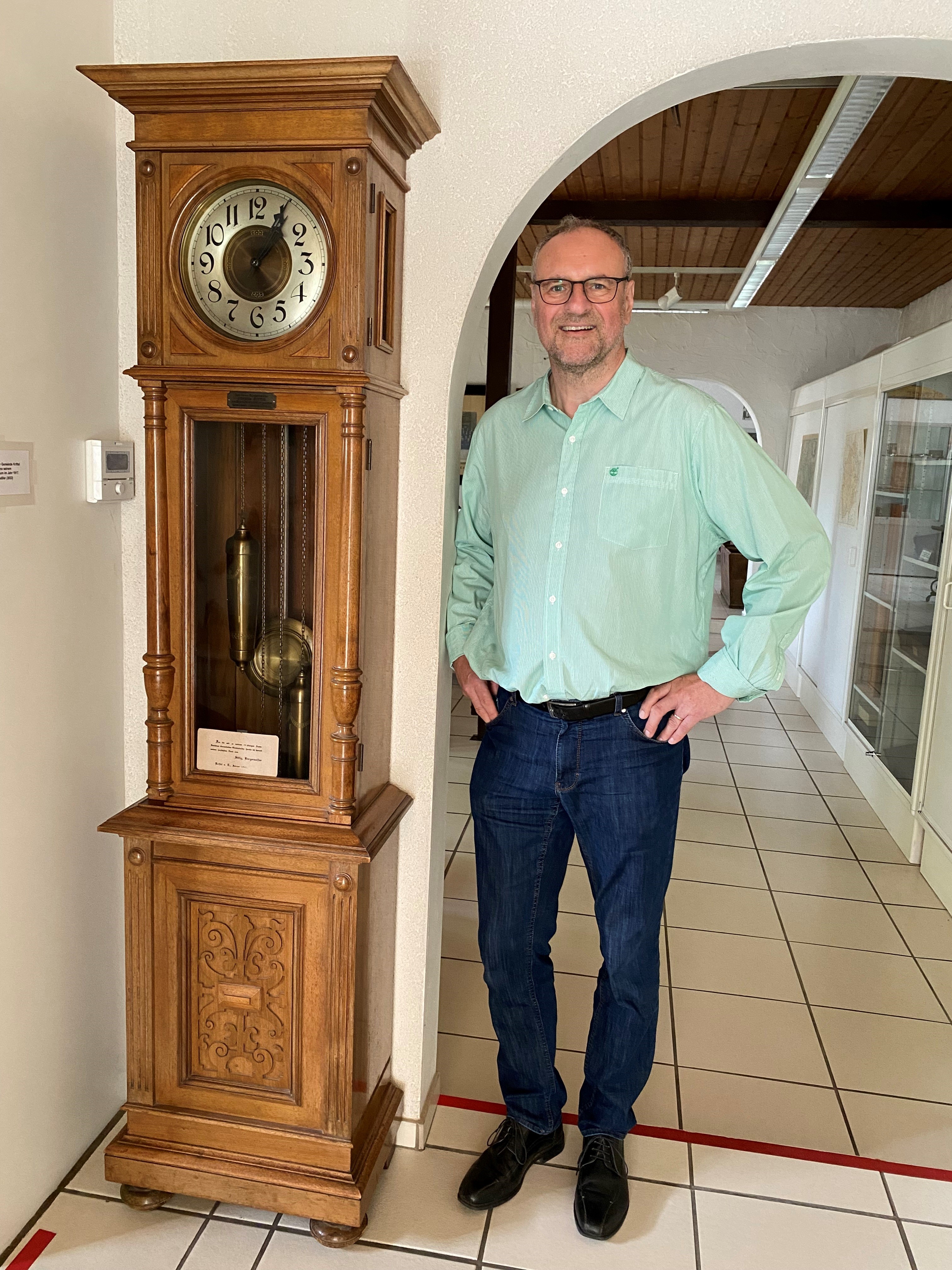 Dr. Krause neben einer alten Standuhr im Museum.