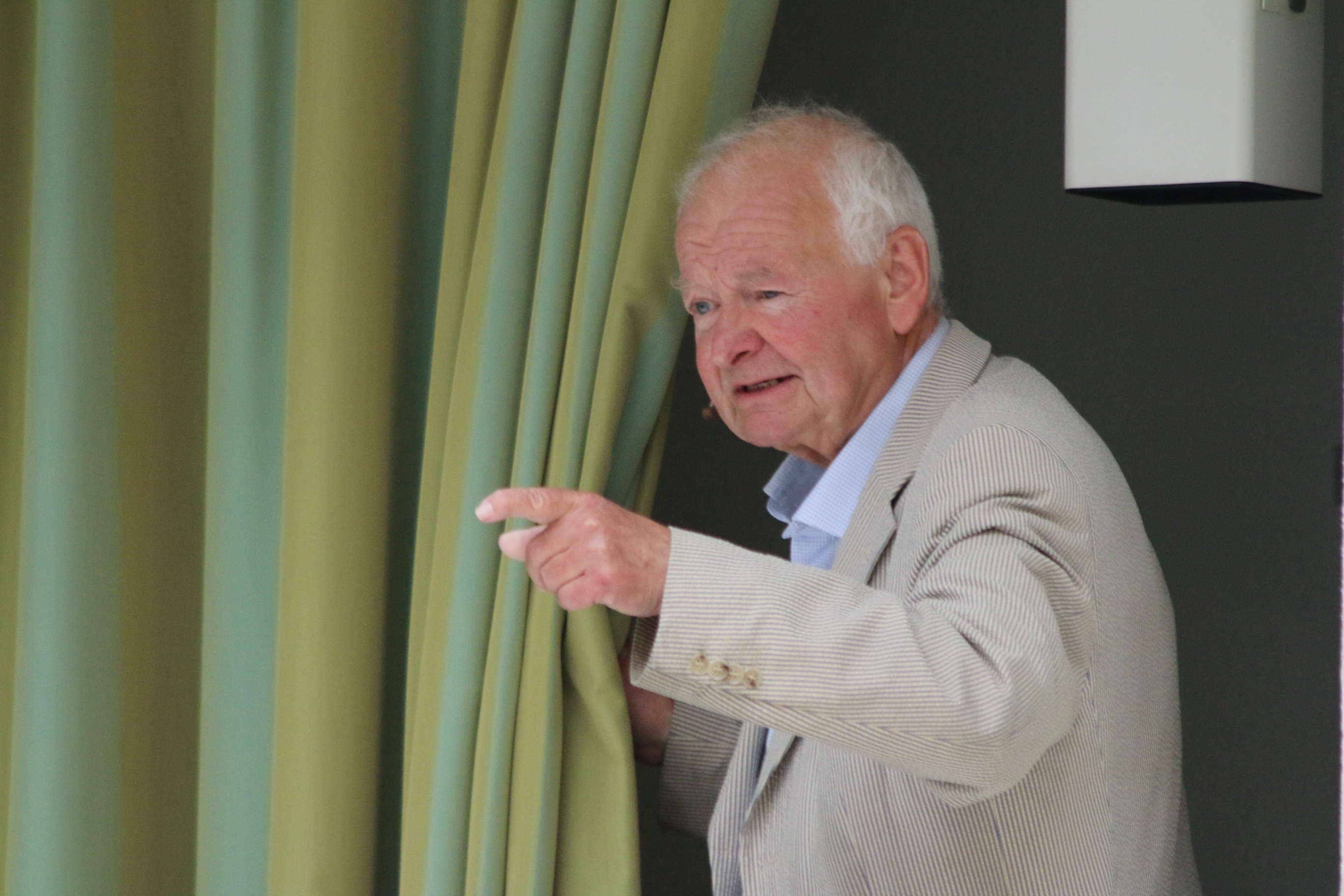 Willi Meyer vor dem Vorhang. Er rezitiert Heine.