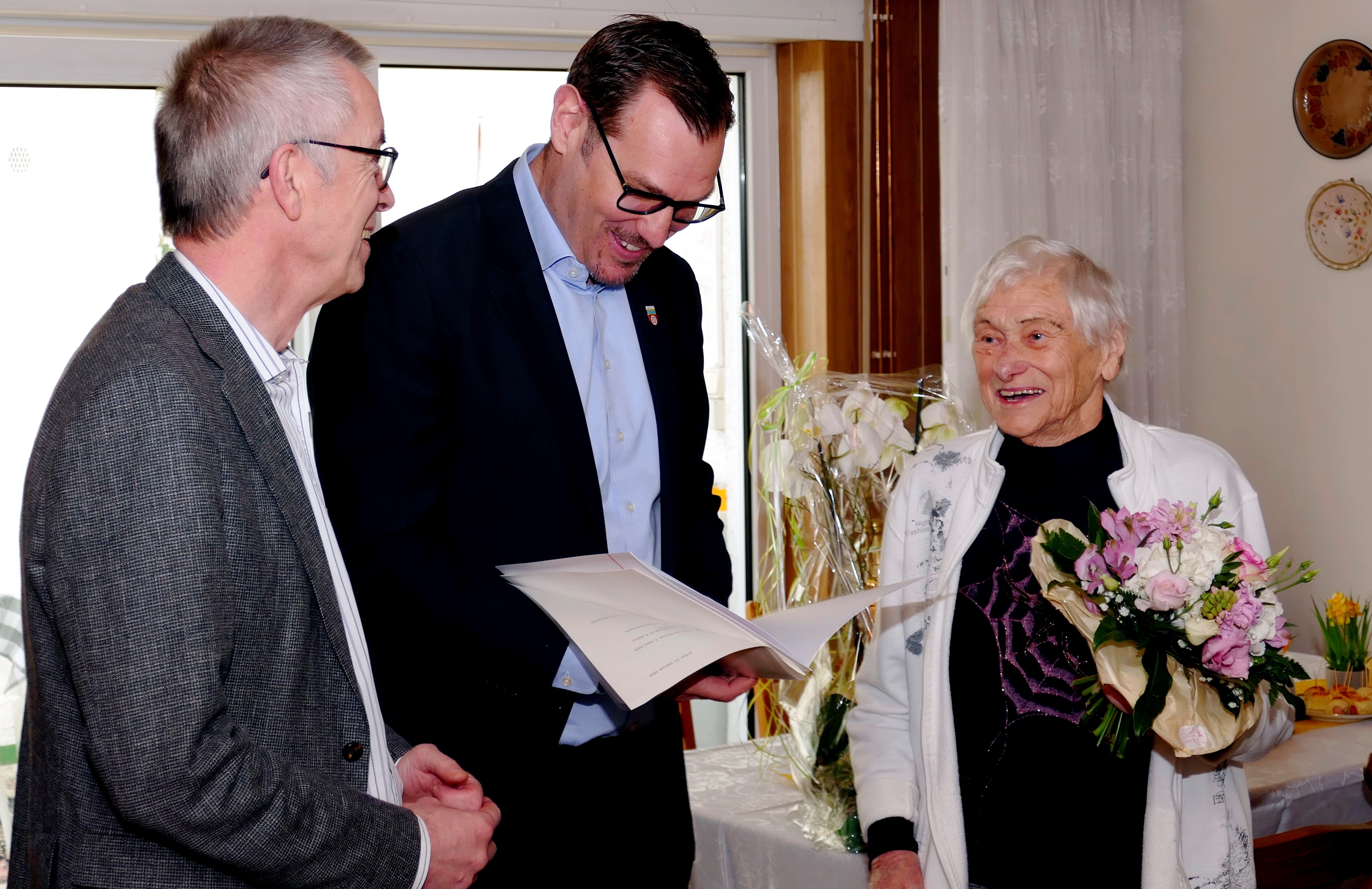 Bürgermeister Christian Seitz liest Hermine Pfaff die Gratulationsurkunden vor. Daneben Franz Jirasek.