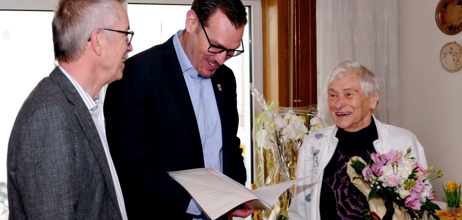 Bürgermeister Christian Seitz liest Hermine Pfaff die Gratulationsurkunden vor. Daneben Franz Jirasek.