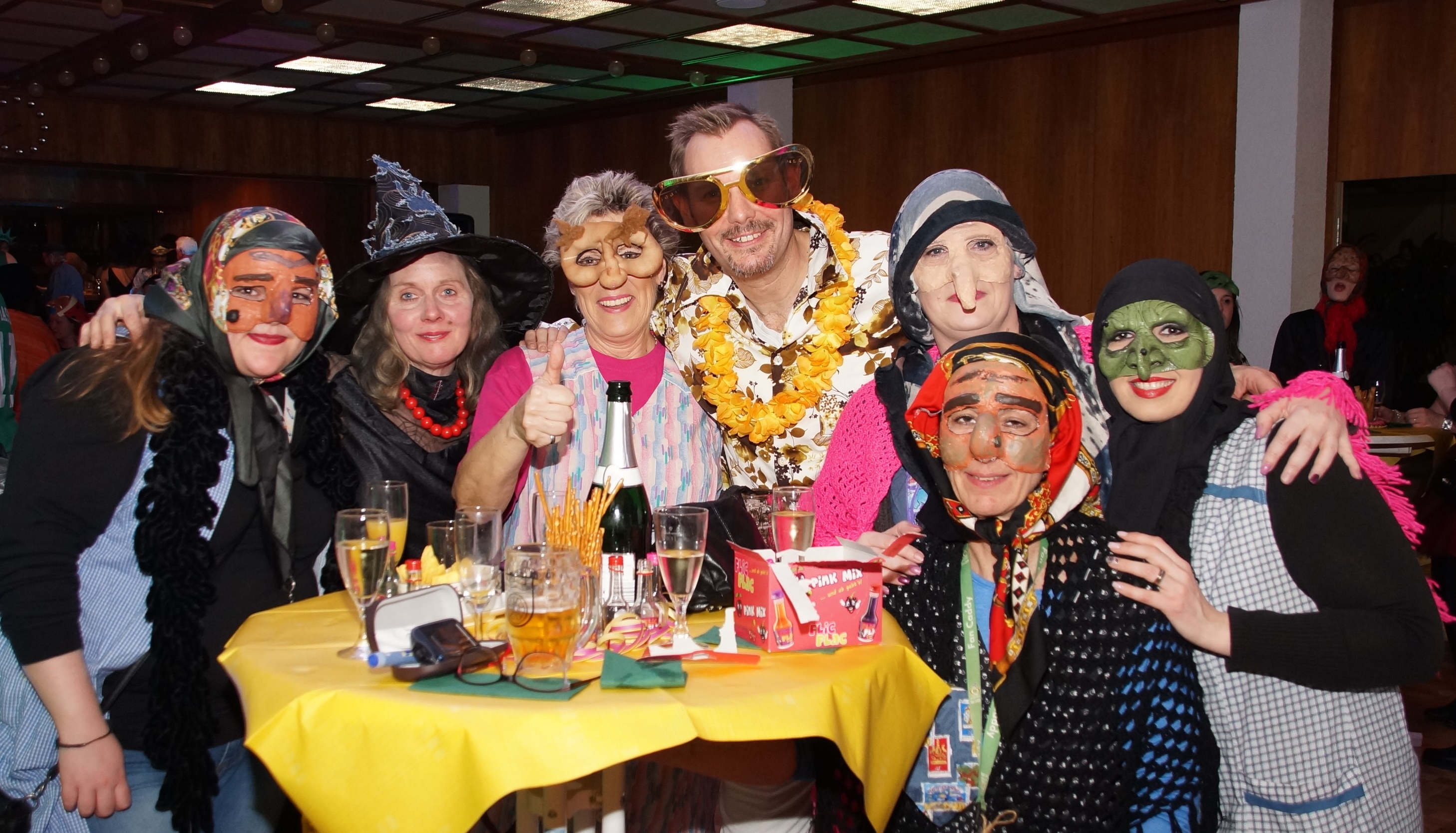 Frauen mit Hexenmasken stehen mit einem verkleideten Bürgermeister gutgelaunt an einem Stehtisch im Rathaus.