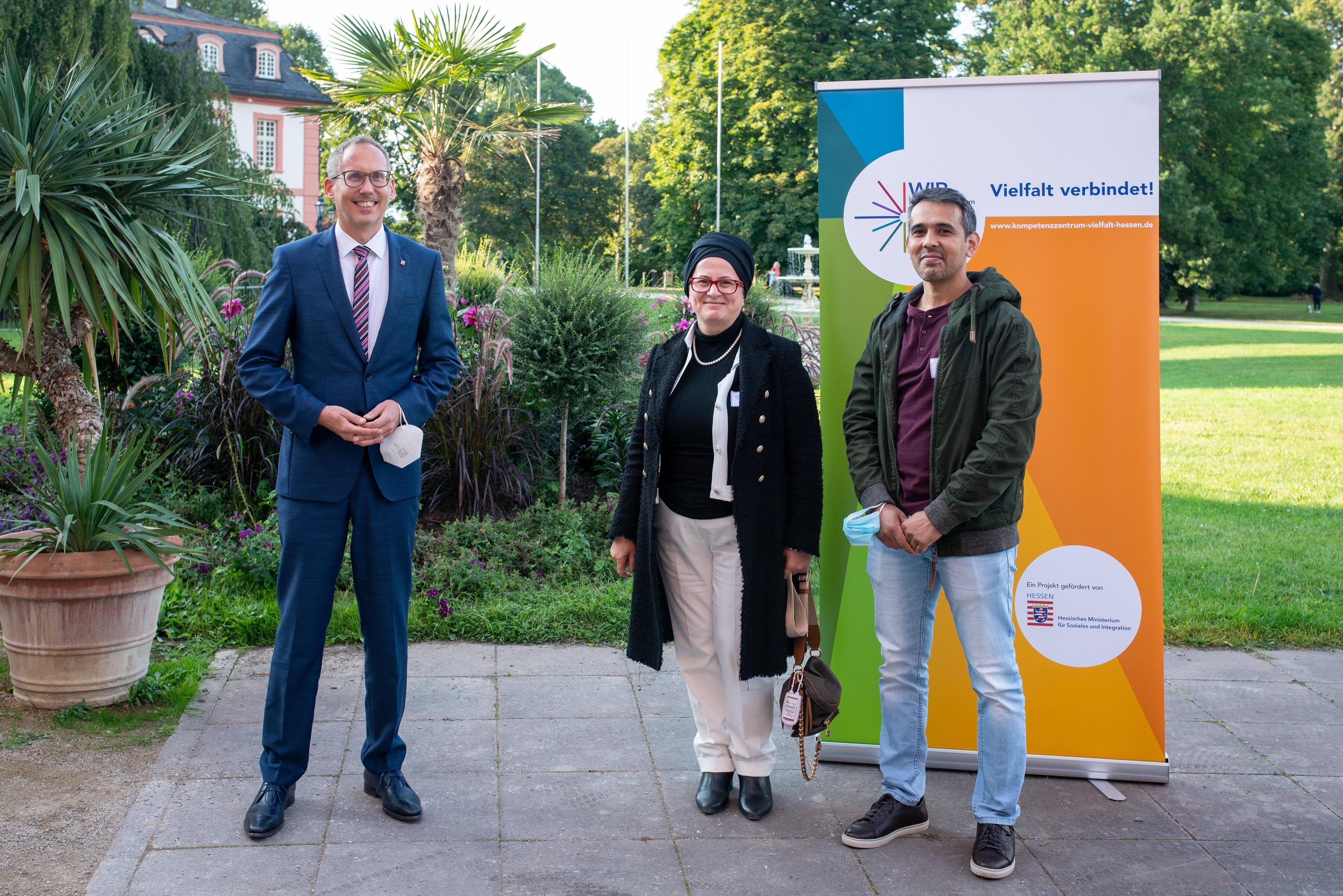 Der Geehrte mit Minister und Krifteler Sozialarbeiterin vor dem Biebricher Schloss.