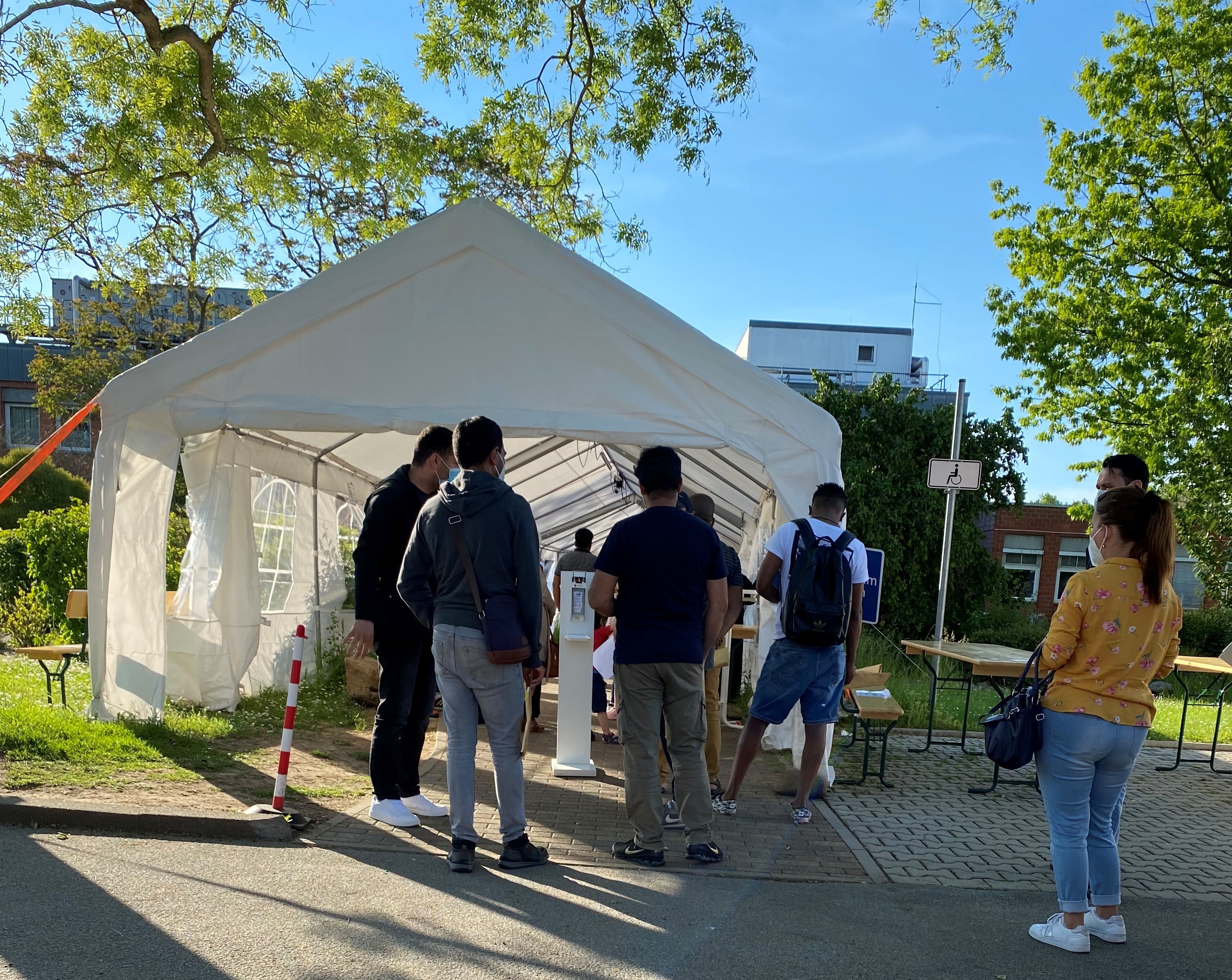 Eine Gruppe wartet vor dem Eingang des Impfzentrums.