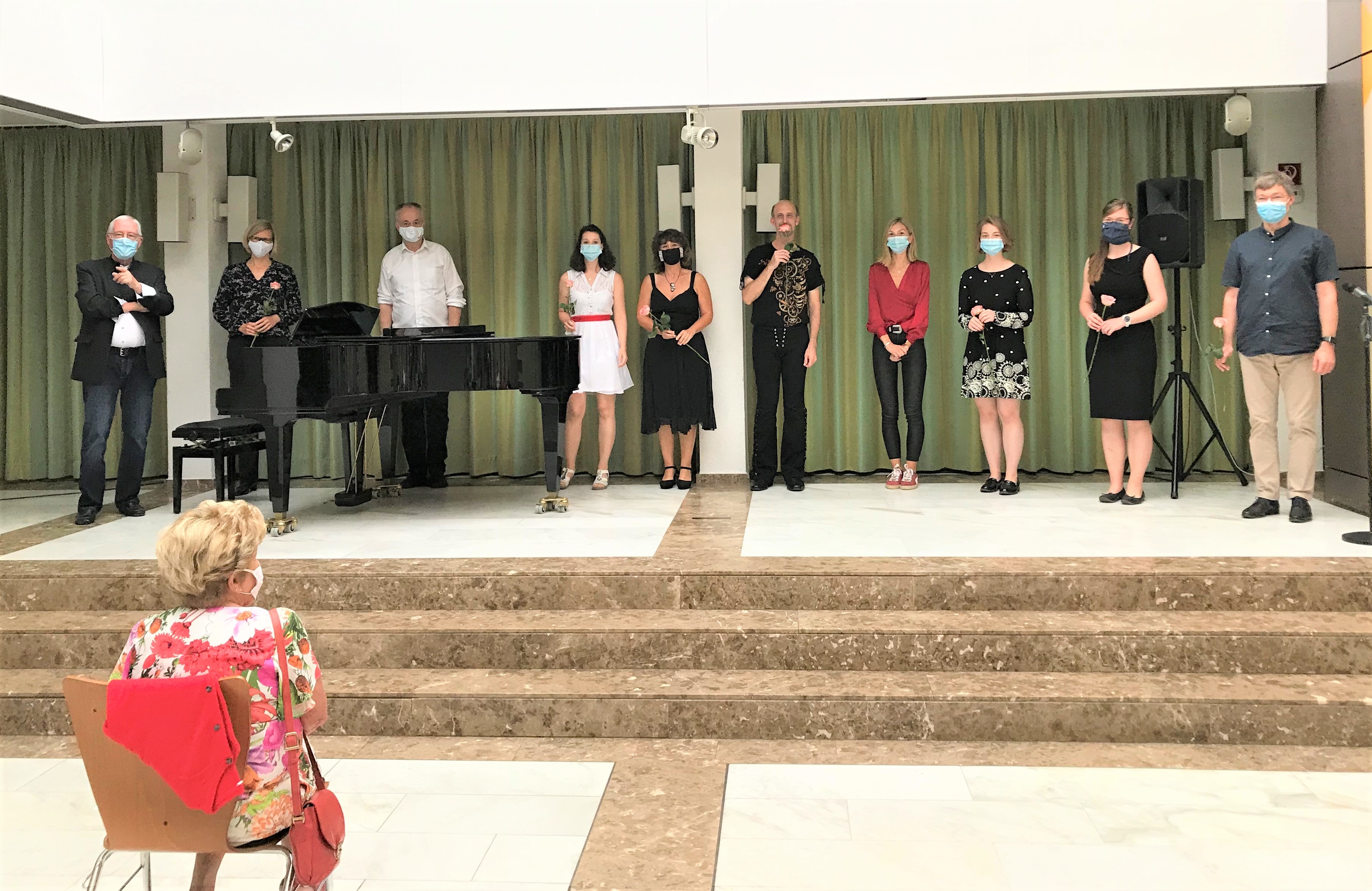 Die Sängerinnen und Sänger mit Mundschutz auf der Bühne.