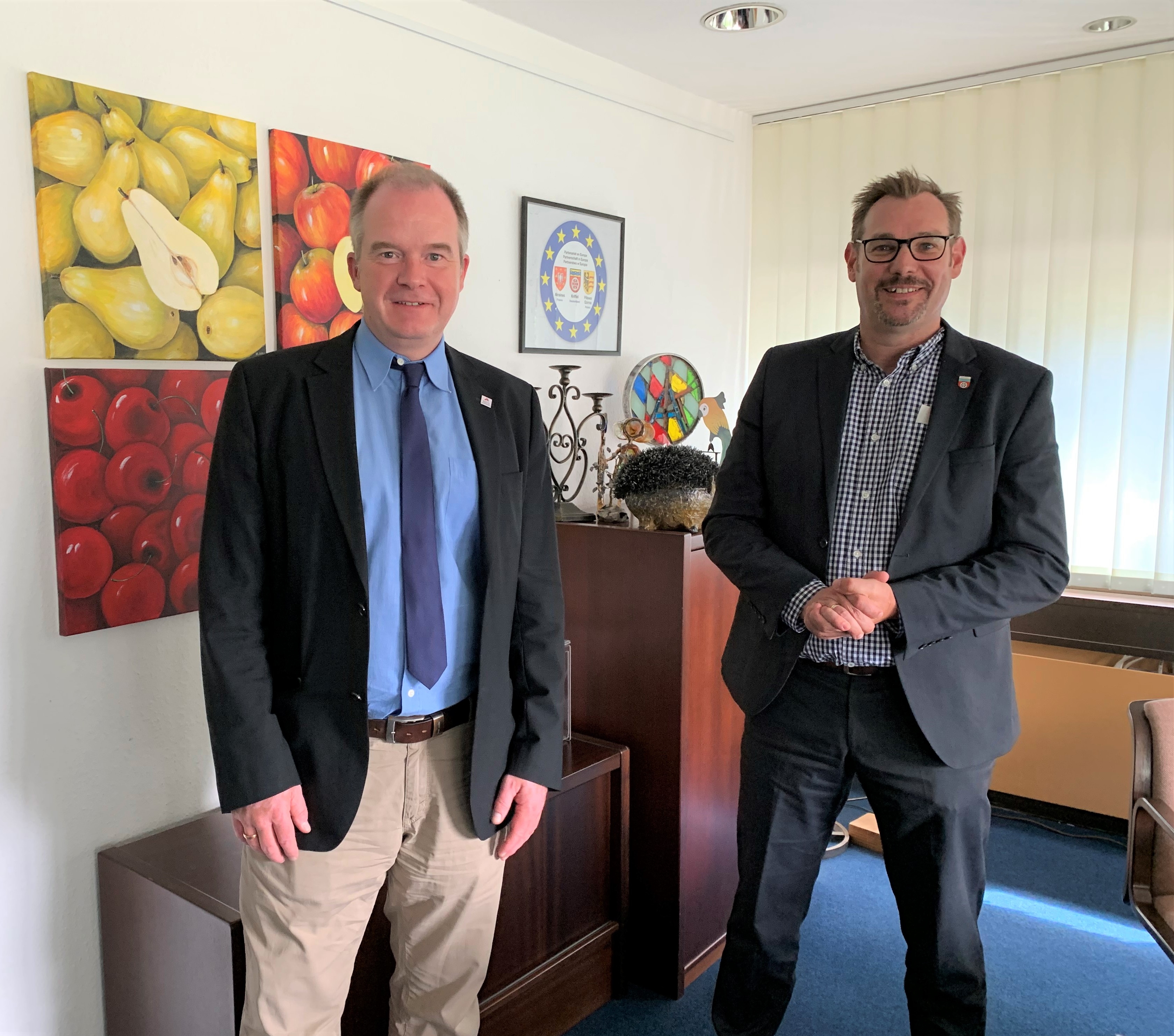 Johannes Heger im Büro von Bürgermeister Christian Seitz. Beide stehen vor Obstbildern.