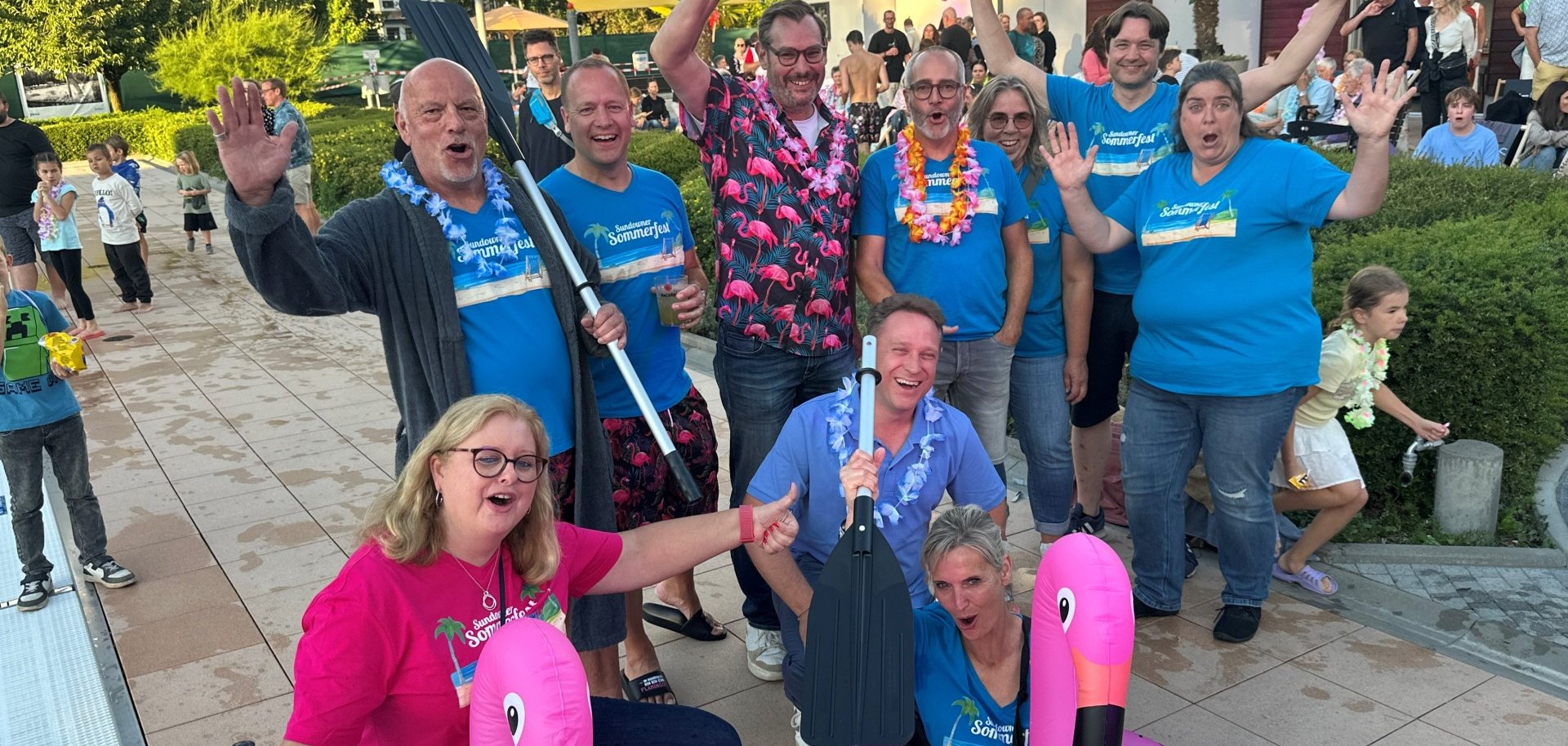 Fröhliche Gruppe mit Ehrengästen und Schwimmtieren.