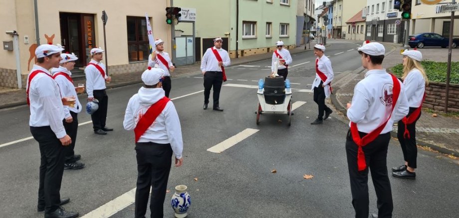 Die Kerbeburschen stehen im Kreis vor der Linde. Rundherum ist es menschenleer.