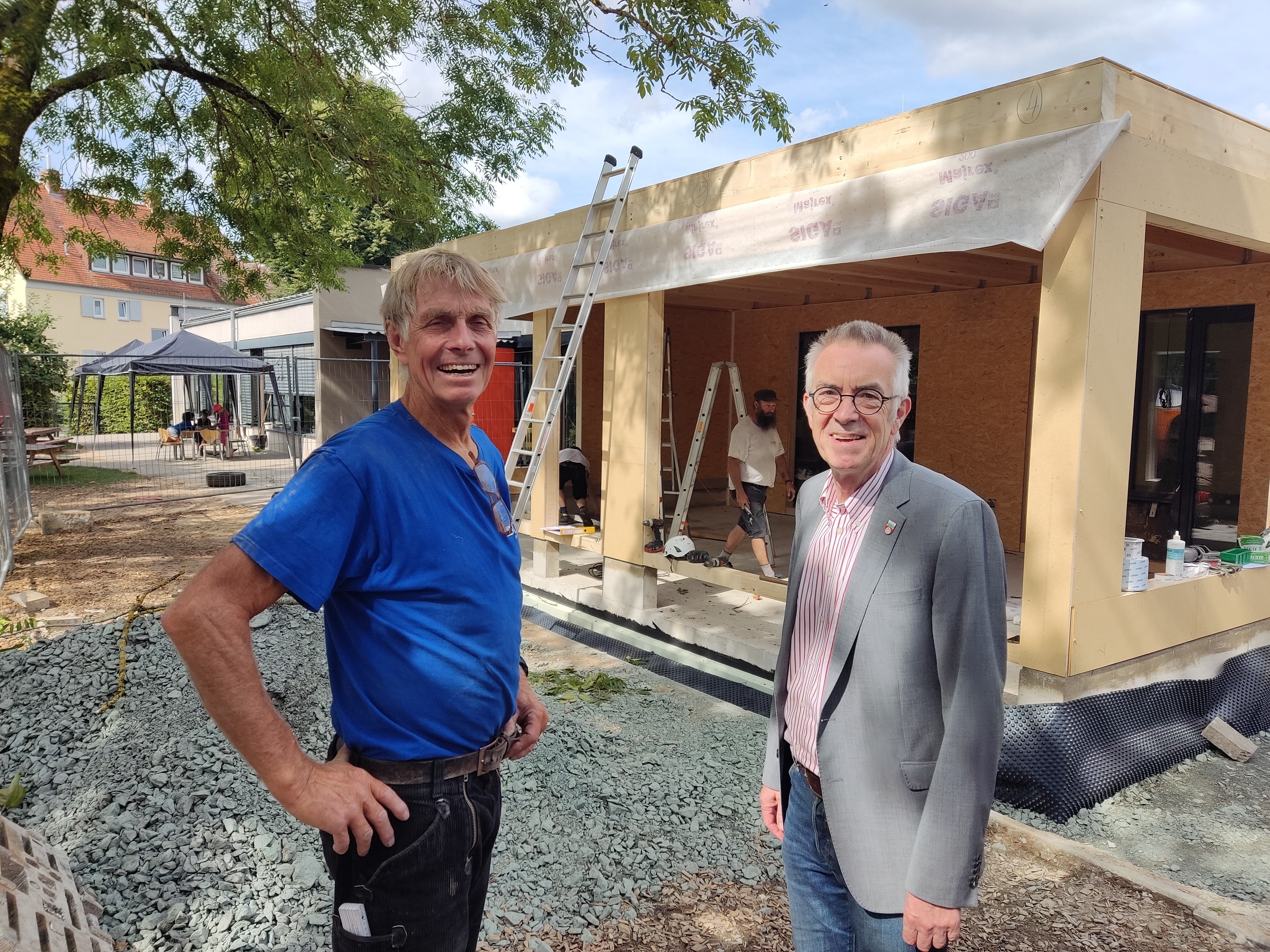 Jirasek mit Vorarbeiter vor dem Holzanbau.