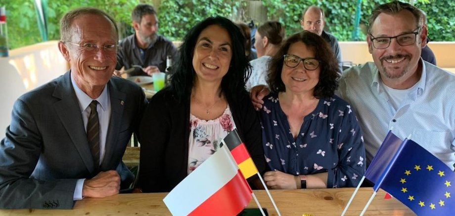 Staatsminister Wintermeyer. Bürgermeister Seitz und Damen des Ausländerbeirates mit Fähnchen.