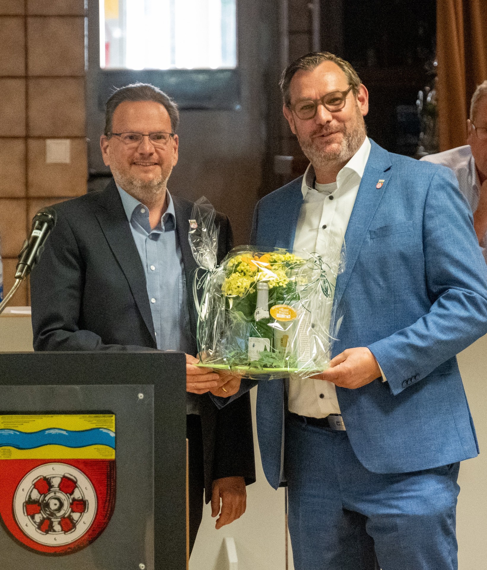 Bürgermeister Seitz übergibt Alexander Feist Blumen.