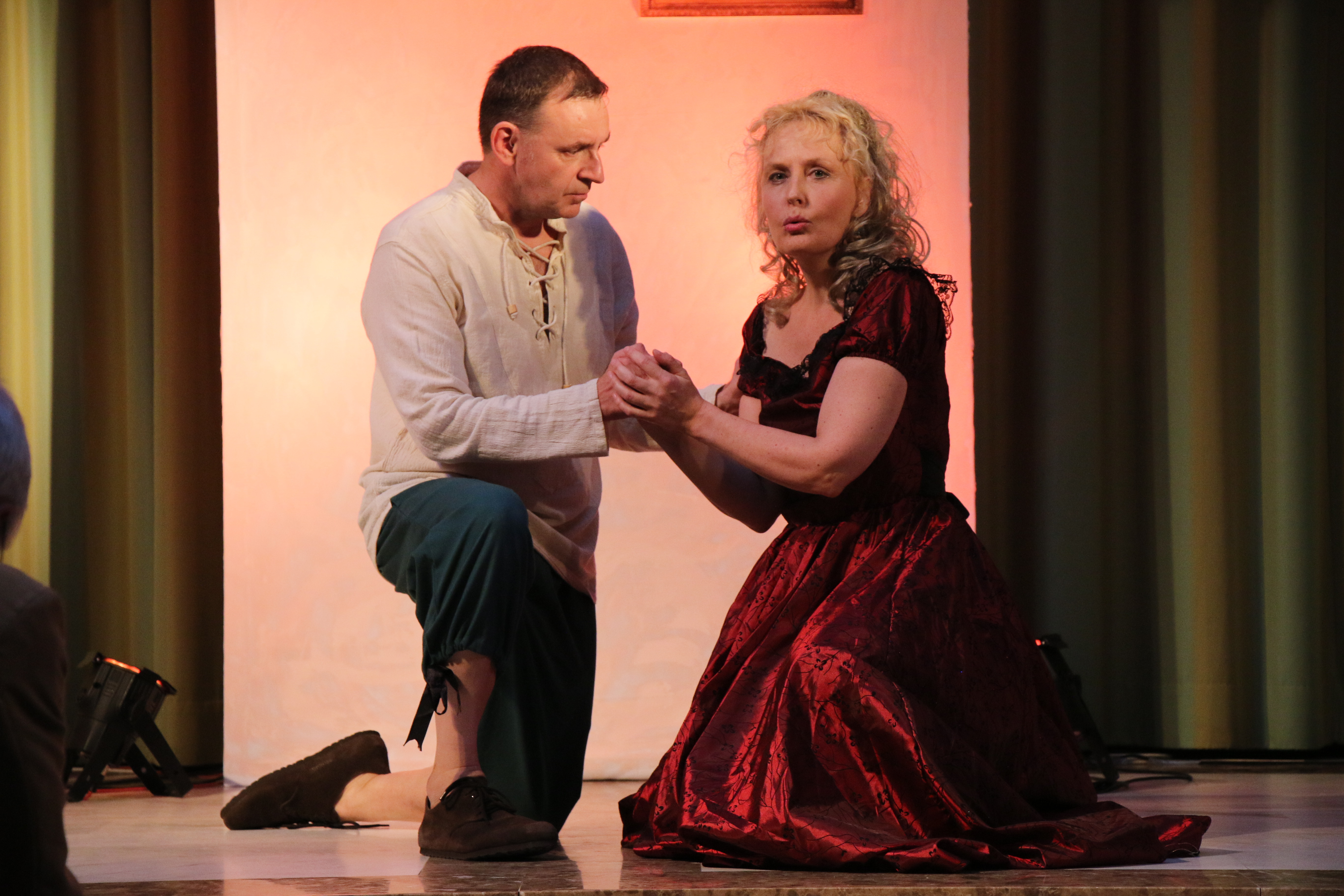 Klaus Gallenbacher und Britta Jacobus knien auf der Konzertbühne.