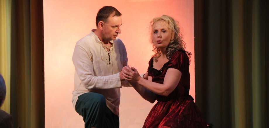 Klaus Gallenbacher und Britta Jacobus knien auf der Konzertbühne.