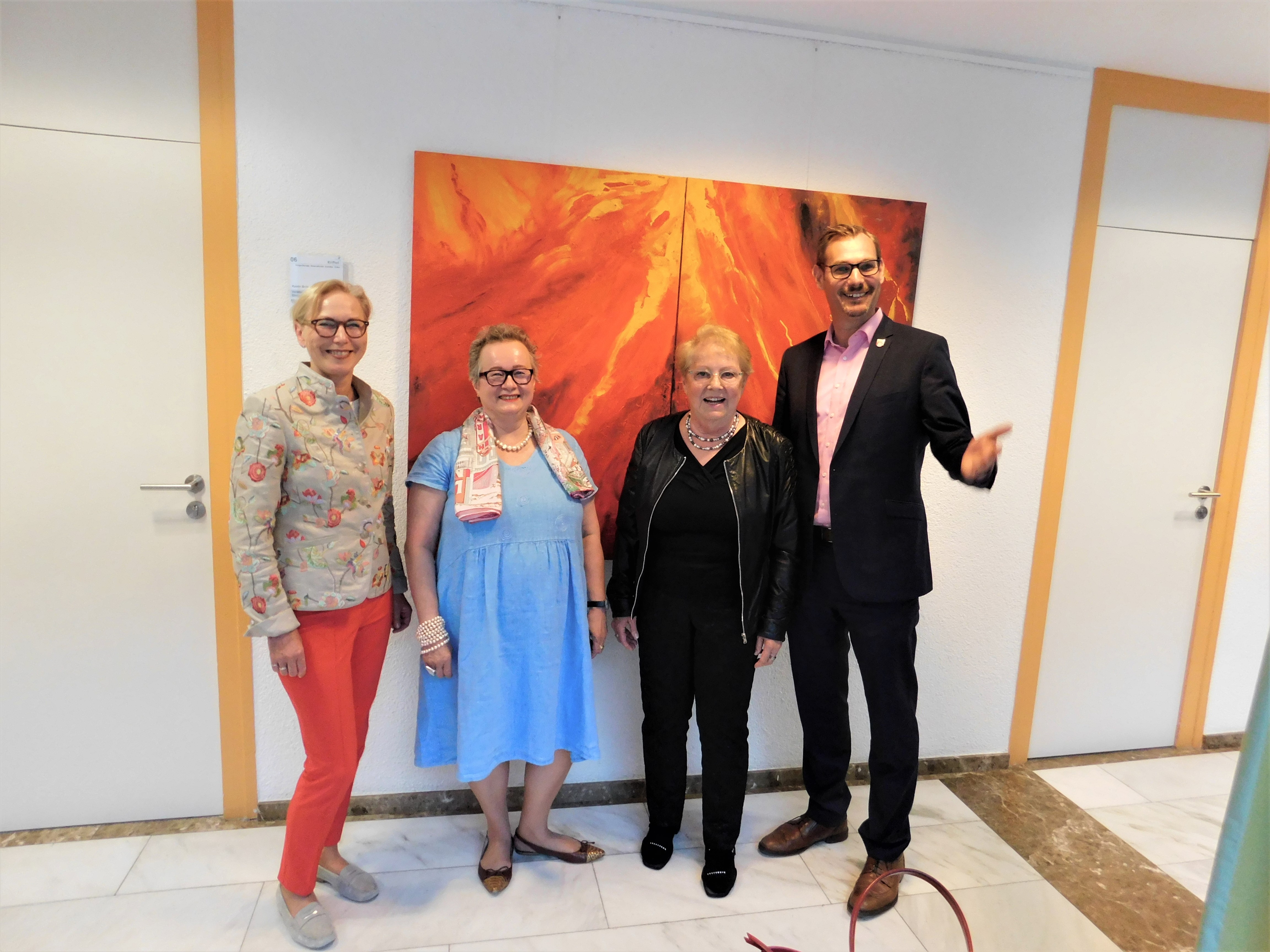 Die Künstlerin mit Gästen vor einem ihrer Werke.