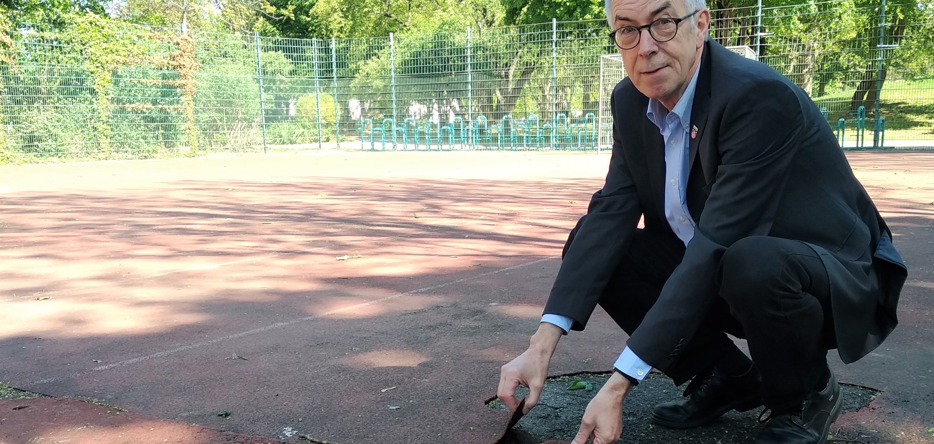 Franz Jirasek zeigt die Schäden am Kunststoffboden. Hier gibt es etliche Stolperfallen.