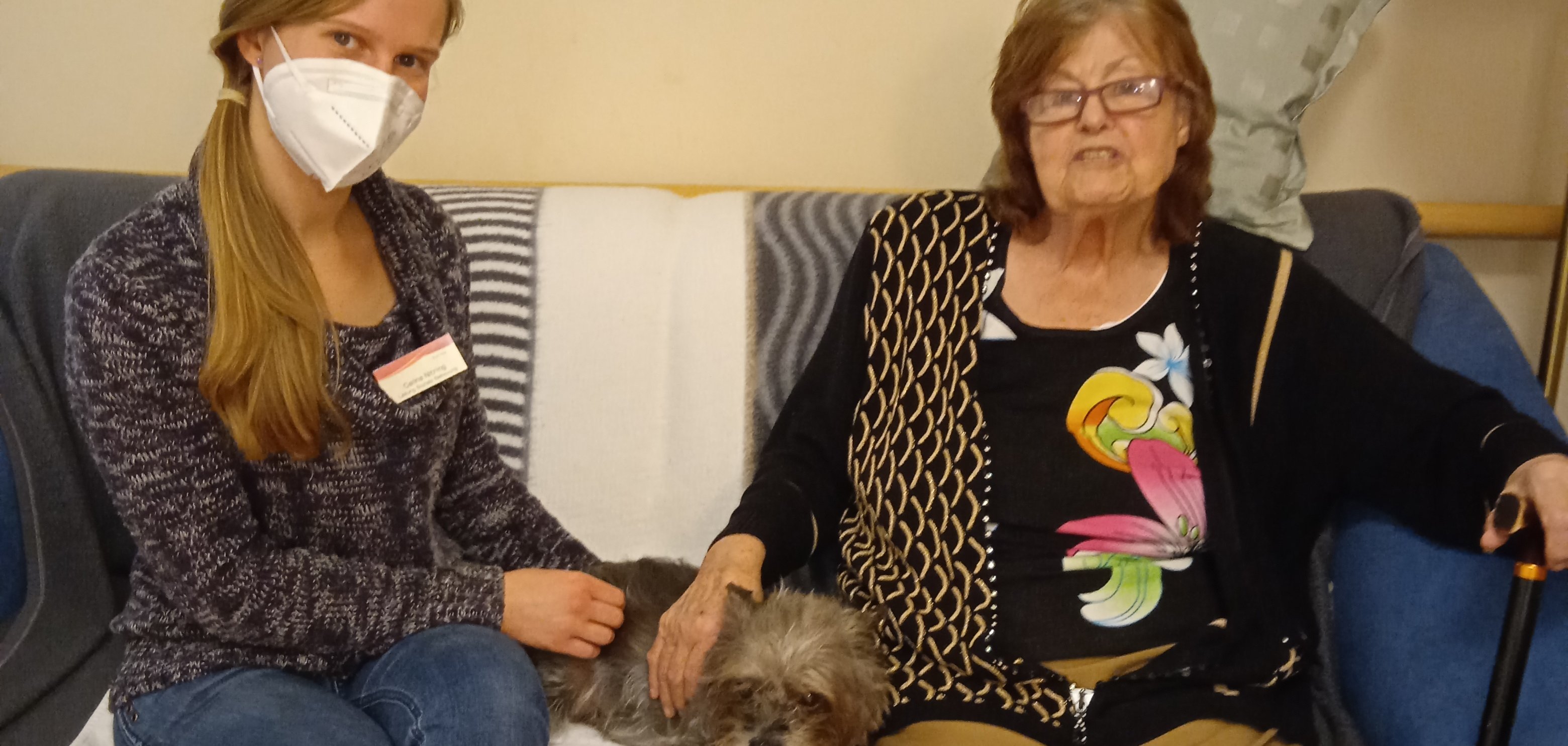 Carina Nitzling, Hündin Blackie und eine Bewohnerin auf dem Sofa.