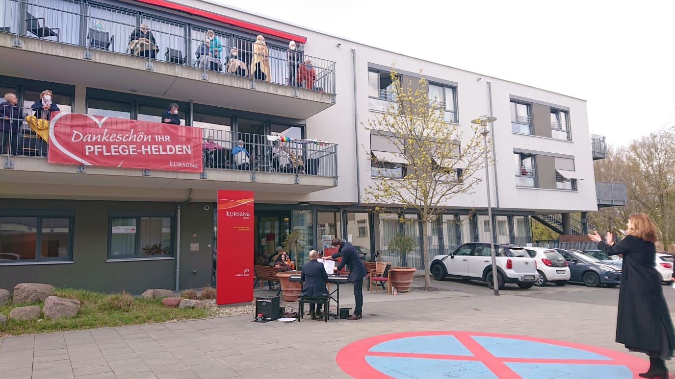 Eine Sopranistin vor dem Kursana Domizil. Das Publikum sitzt auf den Balkonen.