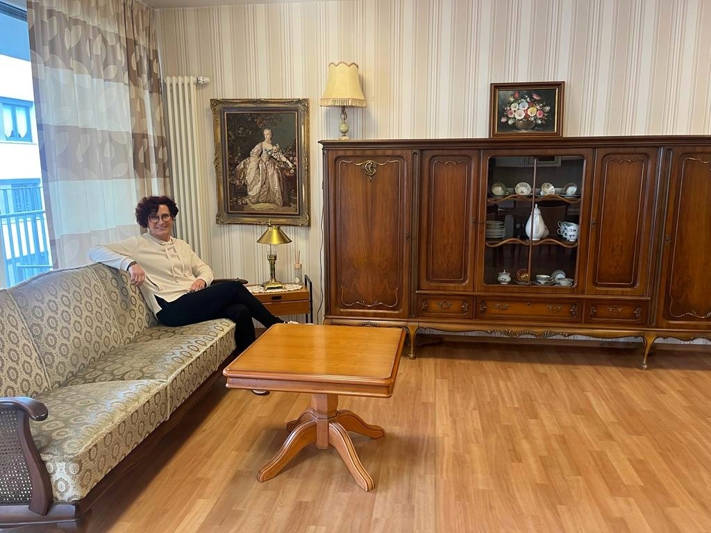 Die Spenderin inmitten alter Möbel.