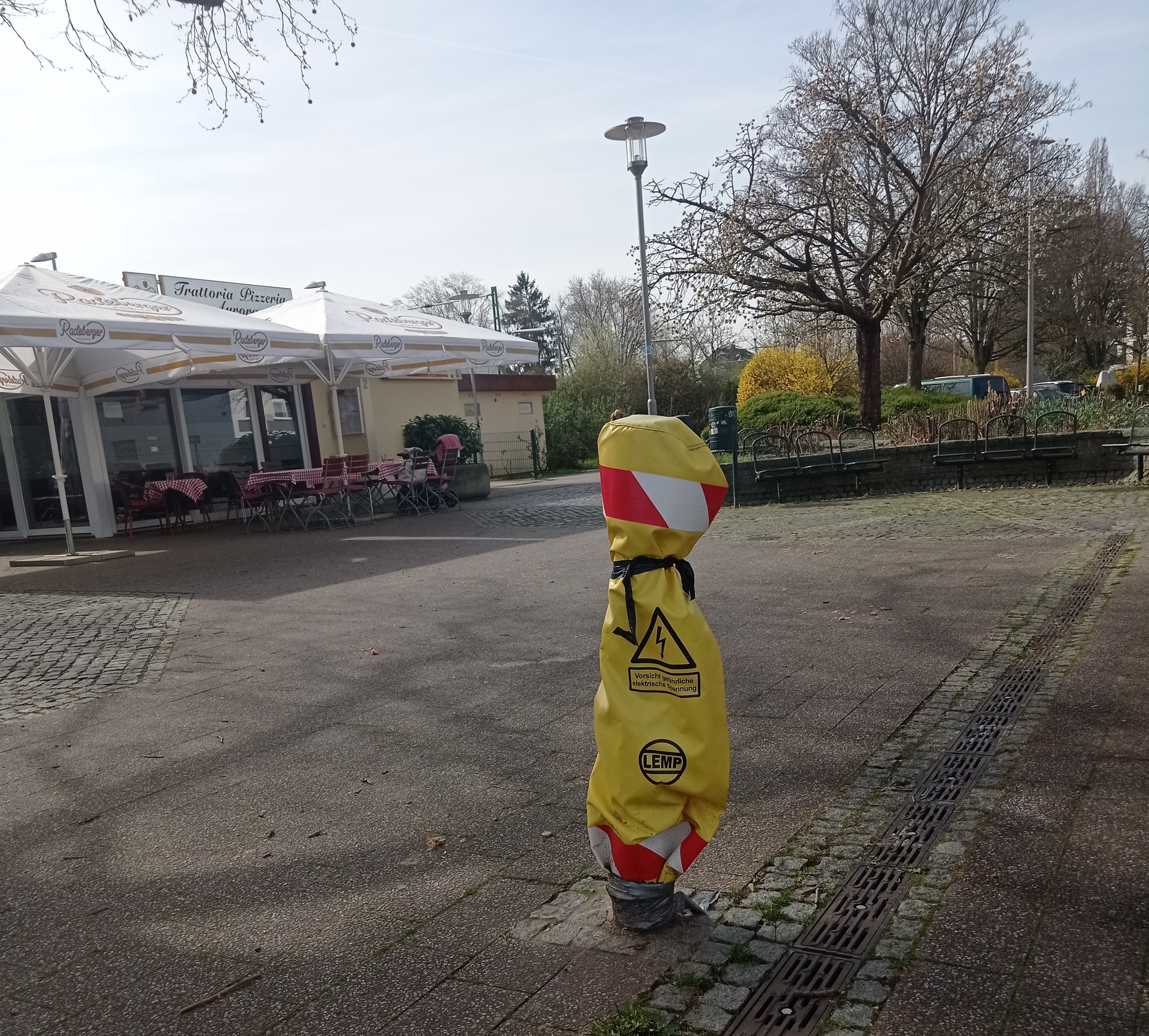 Laternenstumpf mit gelber Abdeckung am Bahnhof.