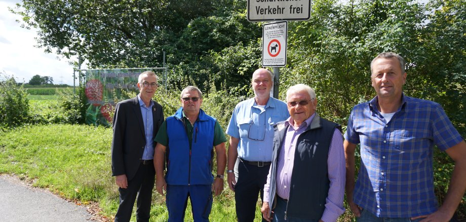 Eine Delegation unter dem neuen Hinweisschild am Eingang zum Hochfeld.