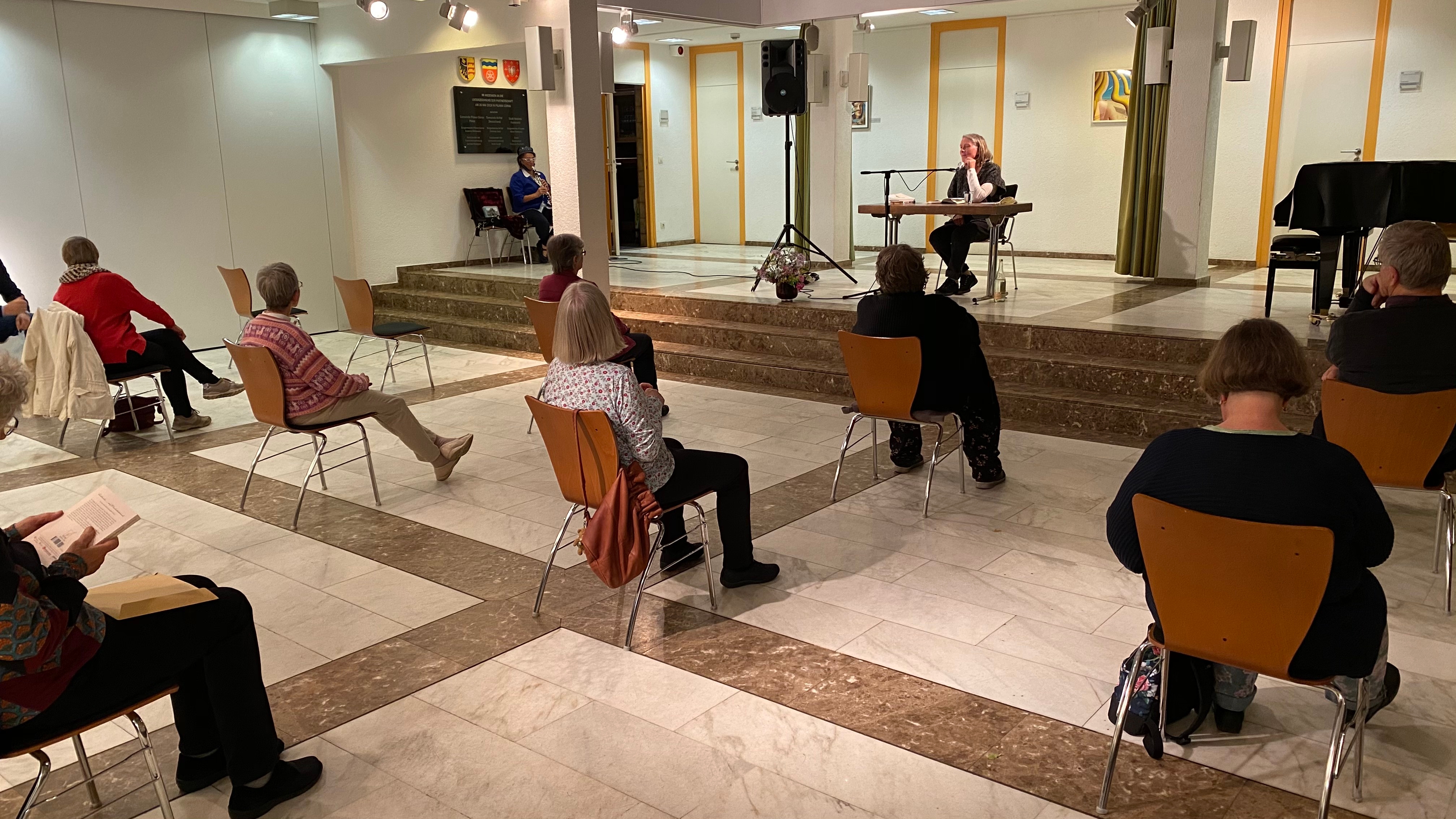 20 Zuhörer mit großen Abständen lauschen Hanna Dunkel im Foyer des Rathauses.