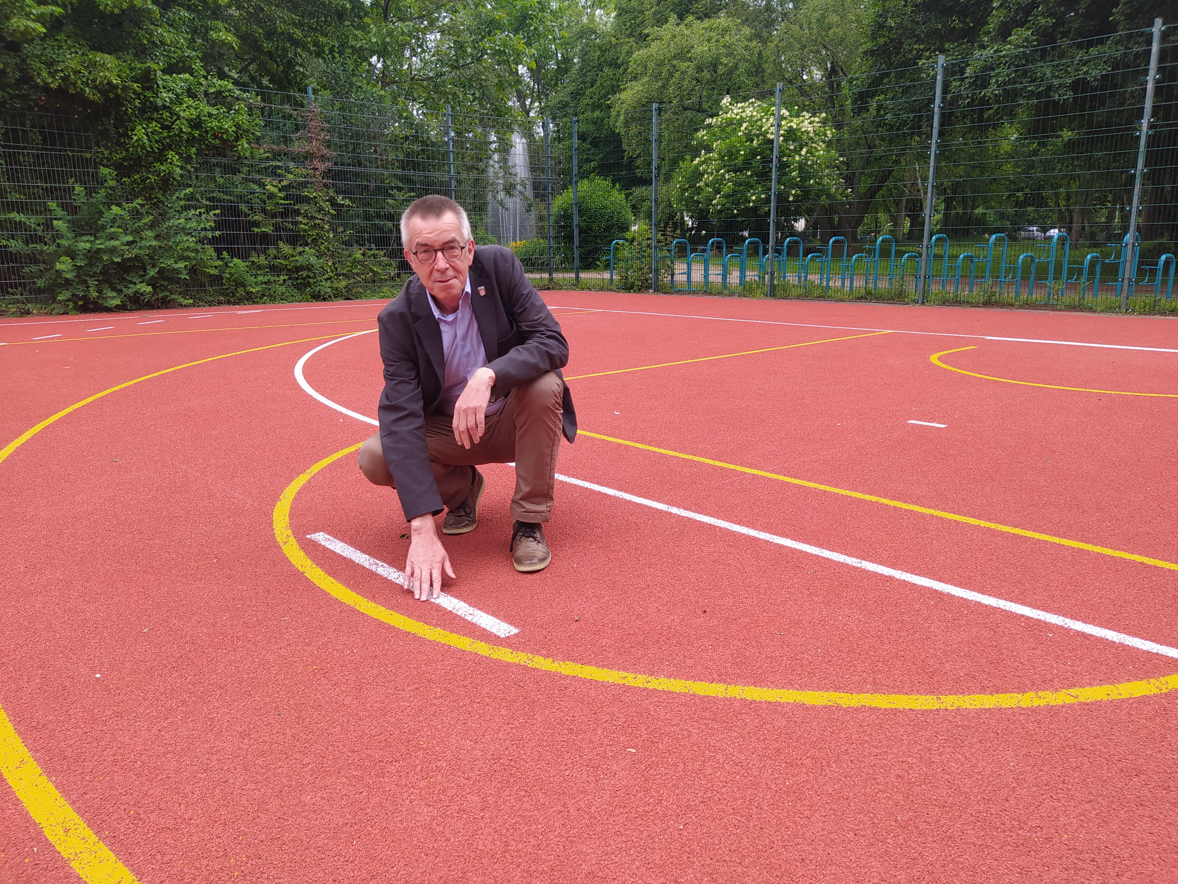 Franz Jirasek auf dem neuen Kunststoffplatz. Er schaut sich die Linierung an.