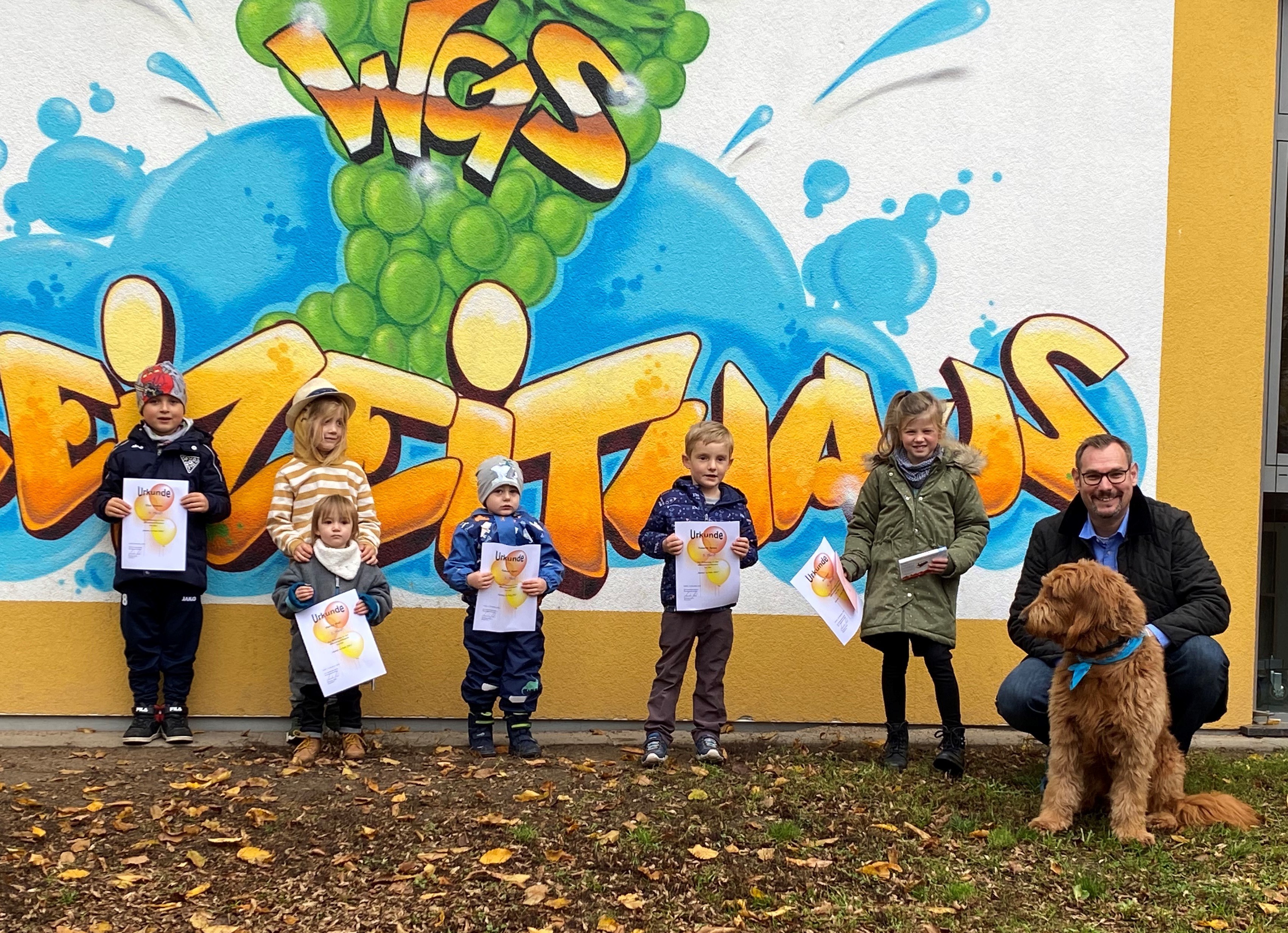 Bürgermeister Seitz mit Hund und den kleinen Gewinnern vorm Freizeithaus.