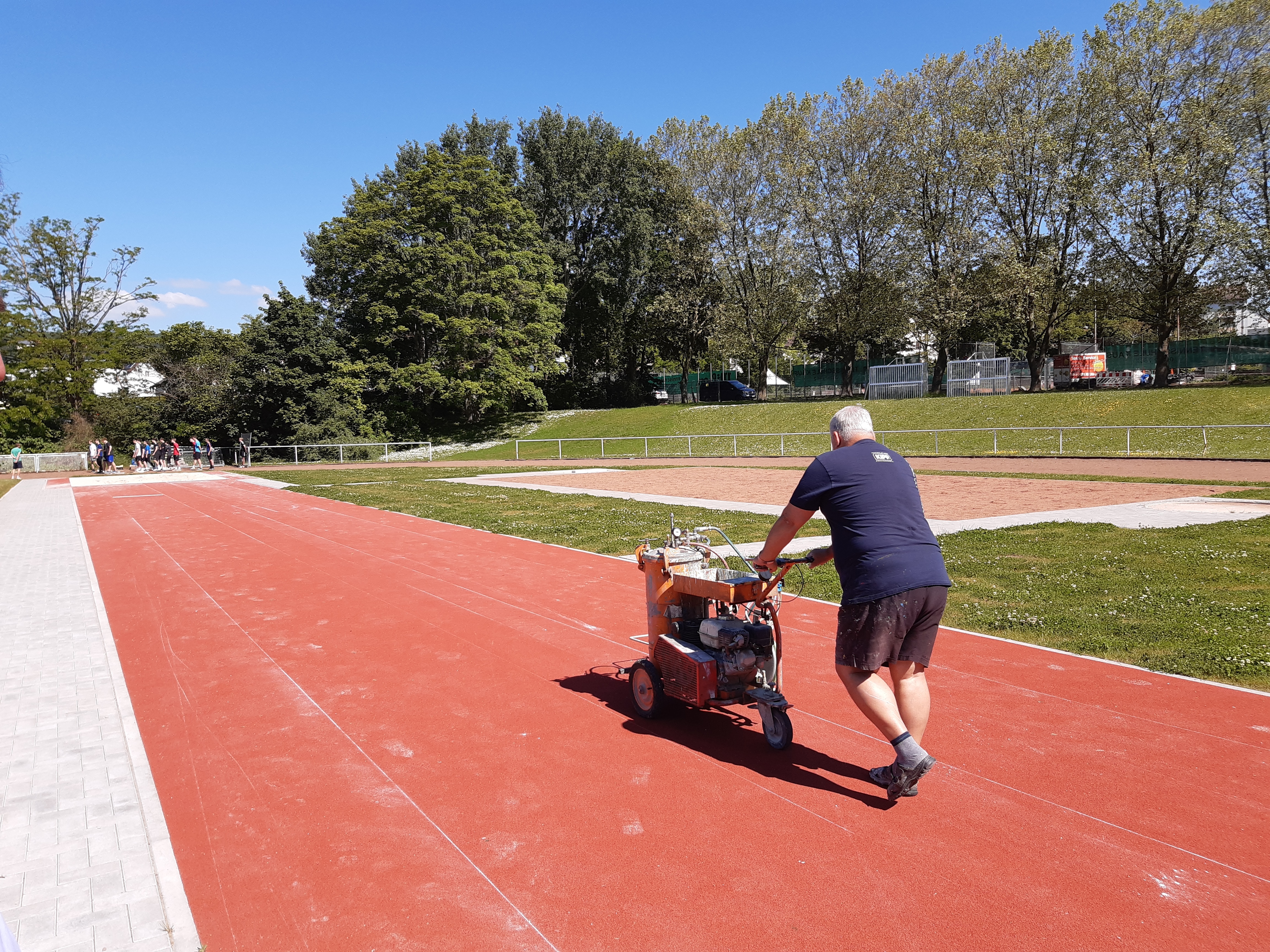 Ein Mann schiebt ein Markierungsgerät.
