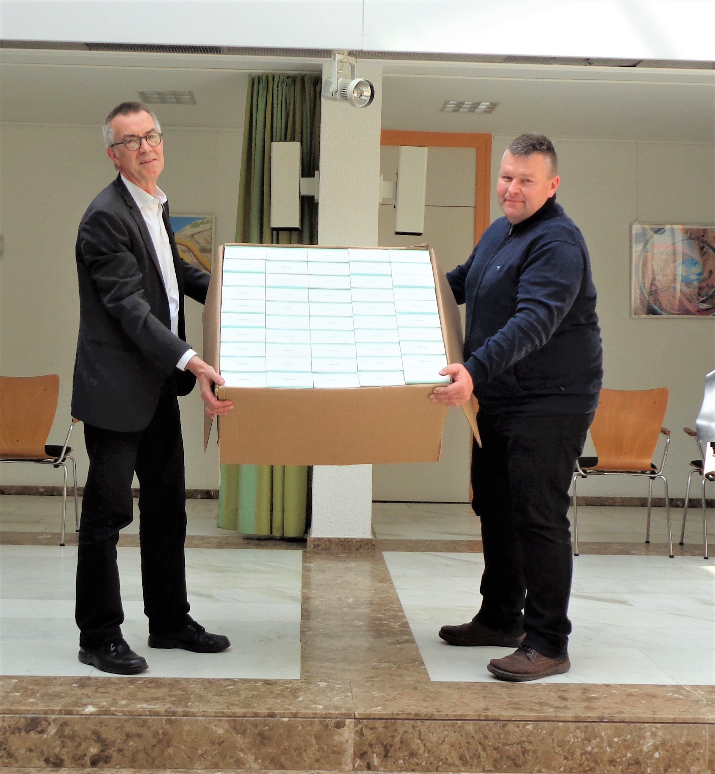 Franz Jirasek nimmt einen großen Karton mit 950 Masken entgegen.